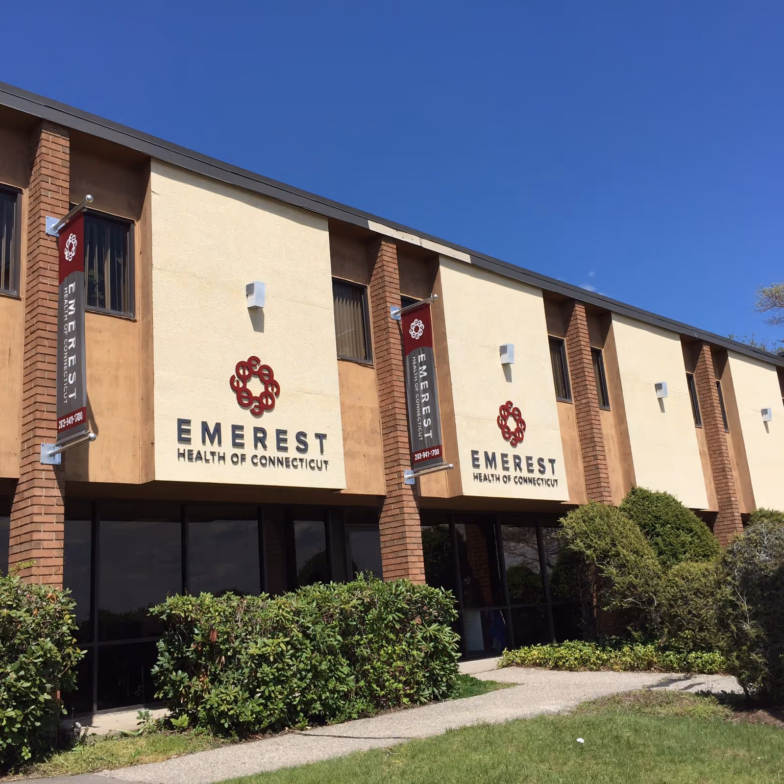 Exterior view of EMEREST Health of Connecticut building with banners.