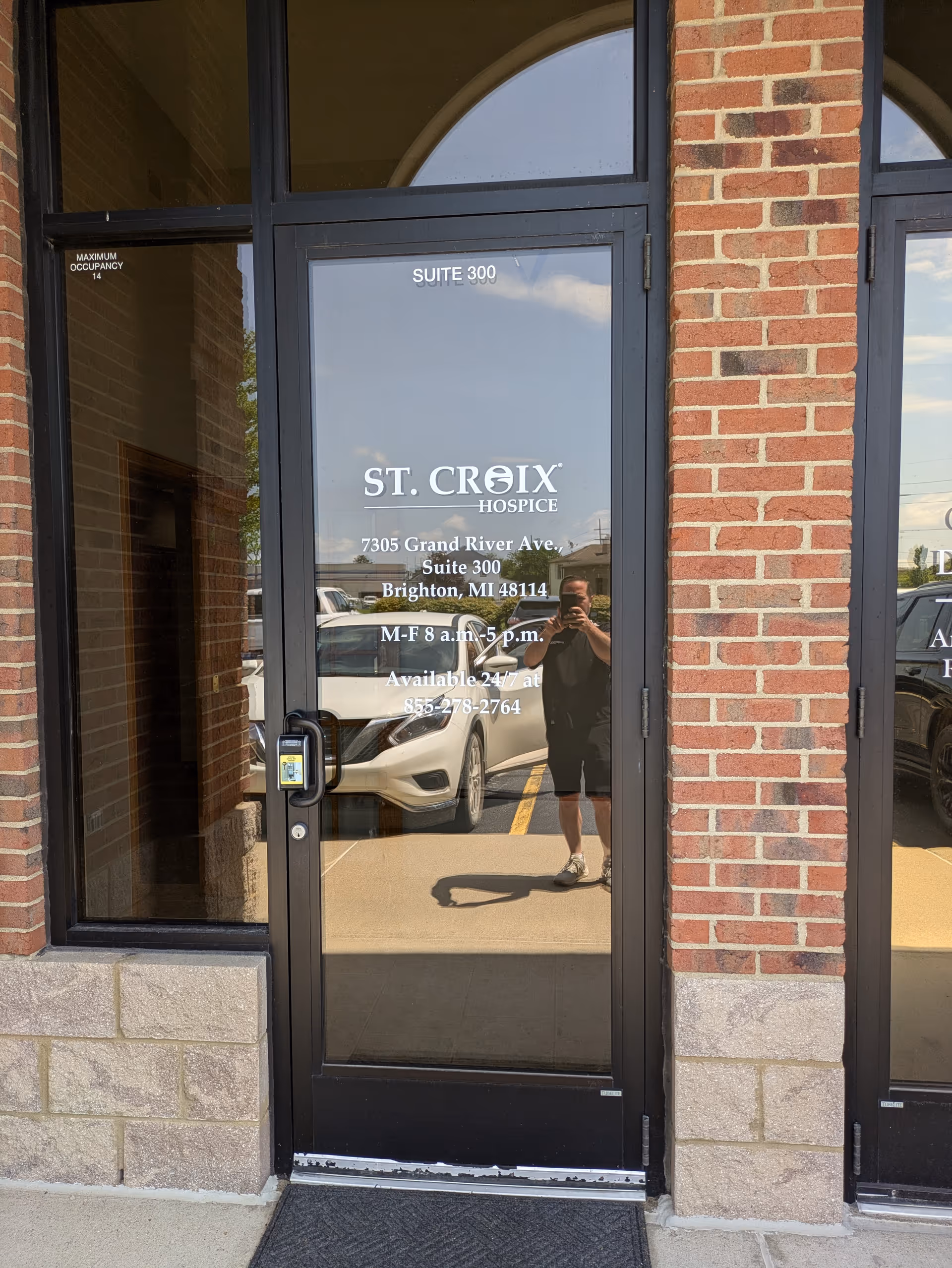Glass door entrance for St. Croix Hospice Suite 300 with brick facade.