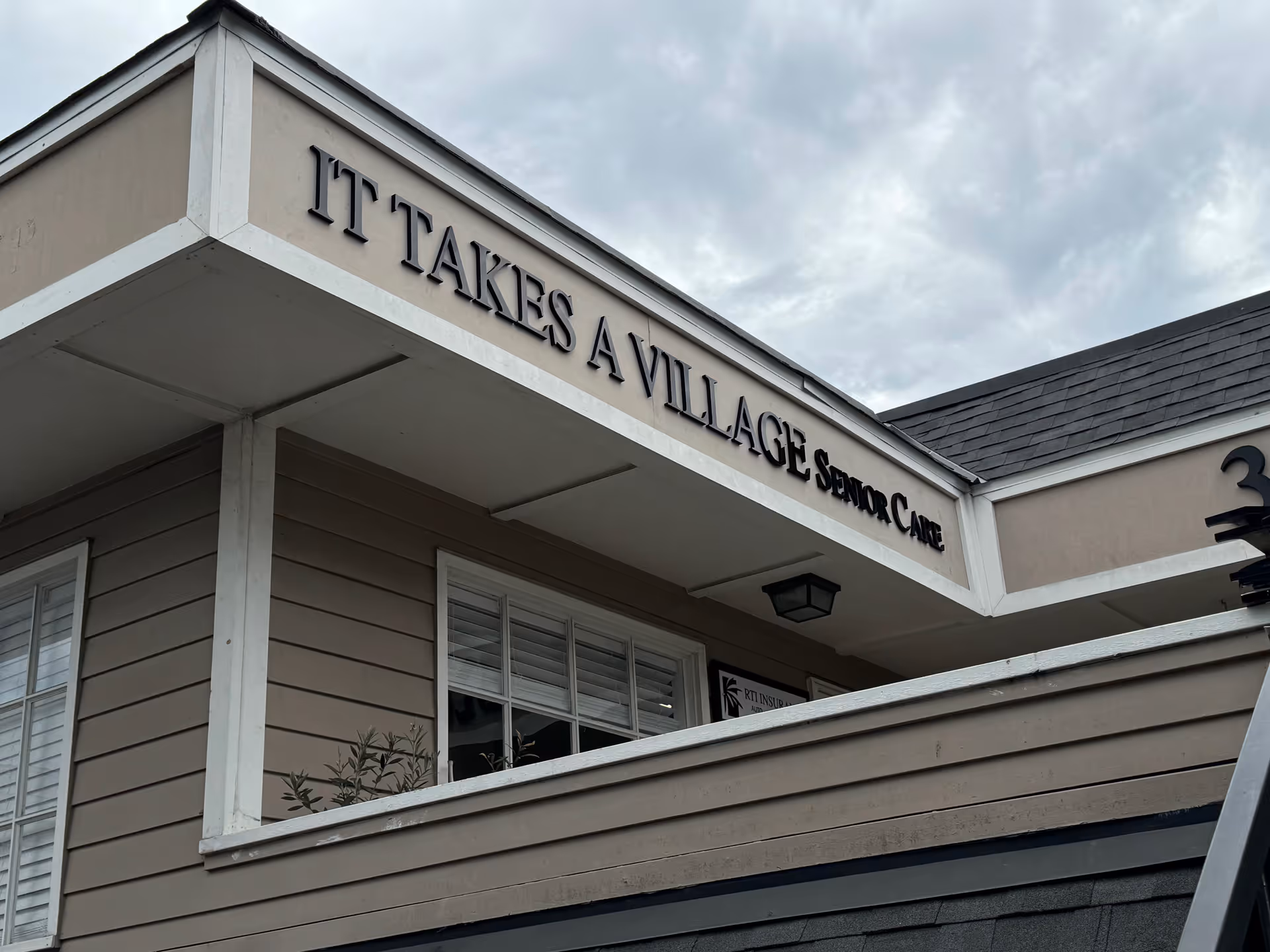 Exterior view of It Takes A Village Senior Care building entrance with its sign.