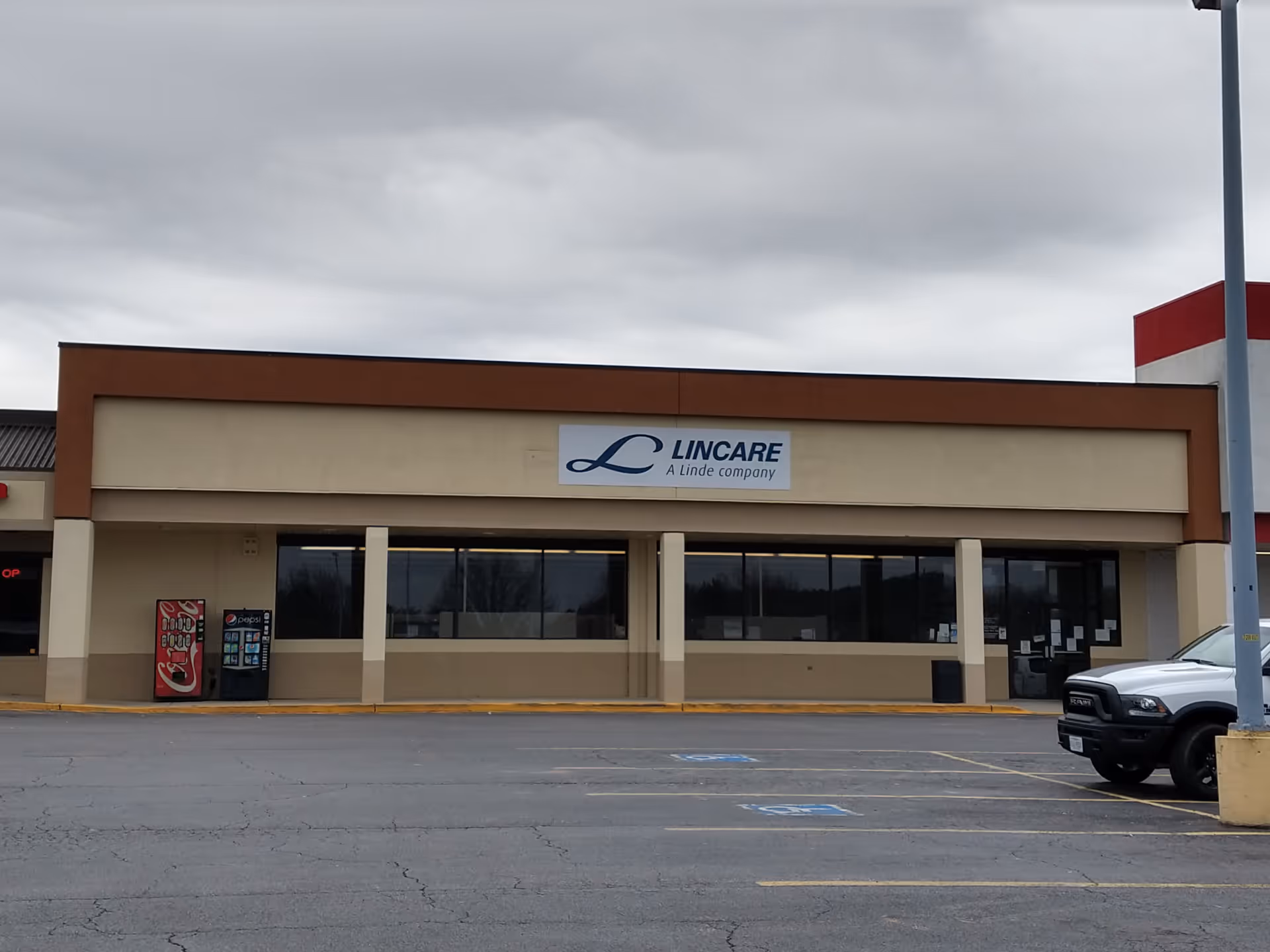 Exterior view of a LINCARE facility storefront with signage and a parking lot.