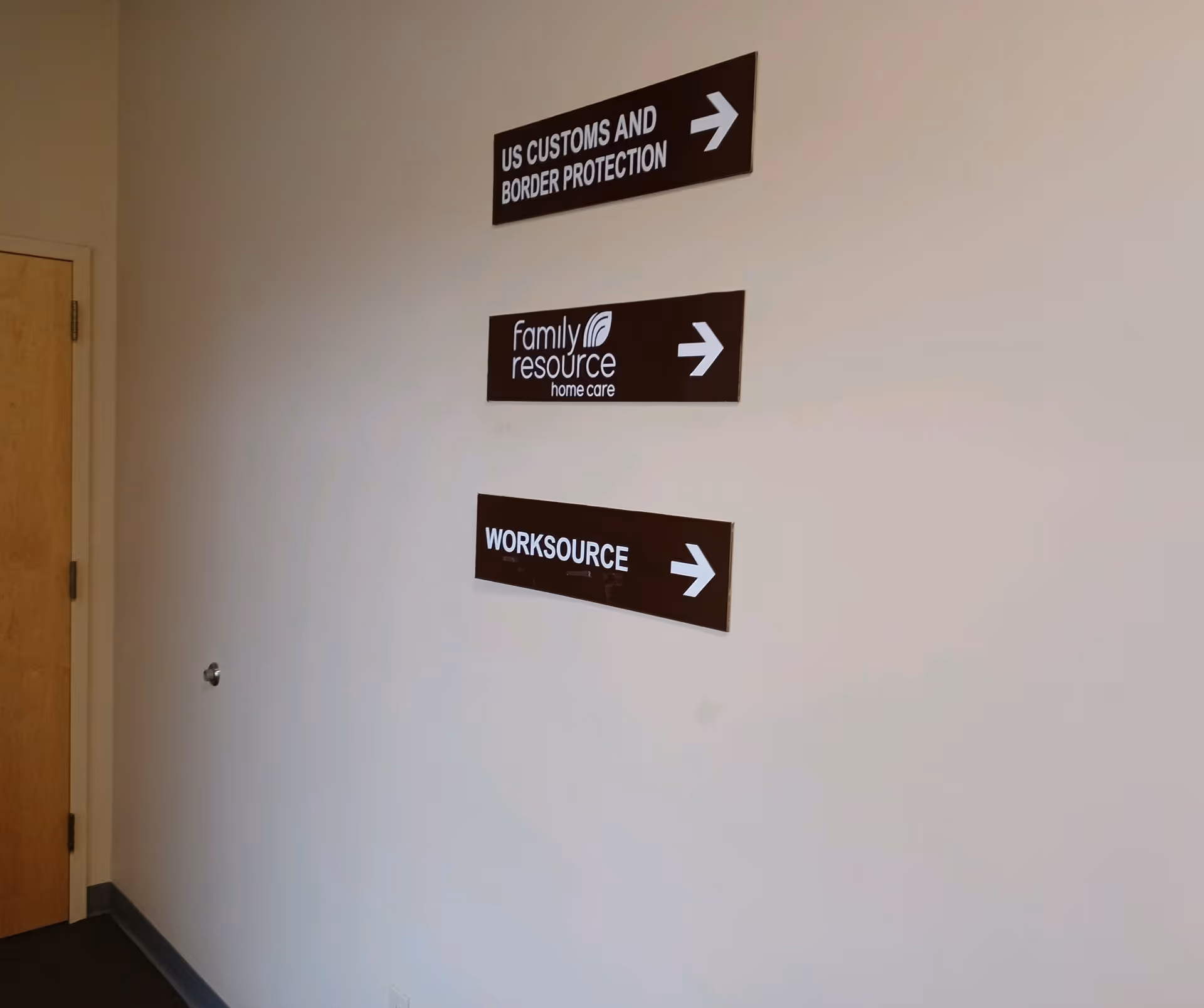 Interior hallway wall with three right-pointing signs, including Family Resource Home Care.