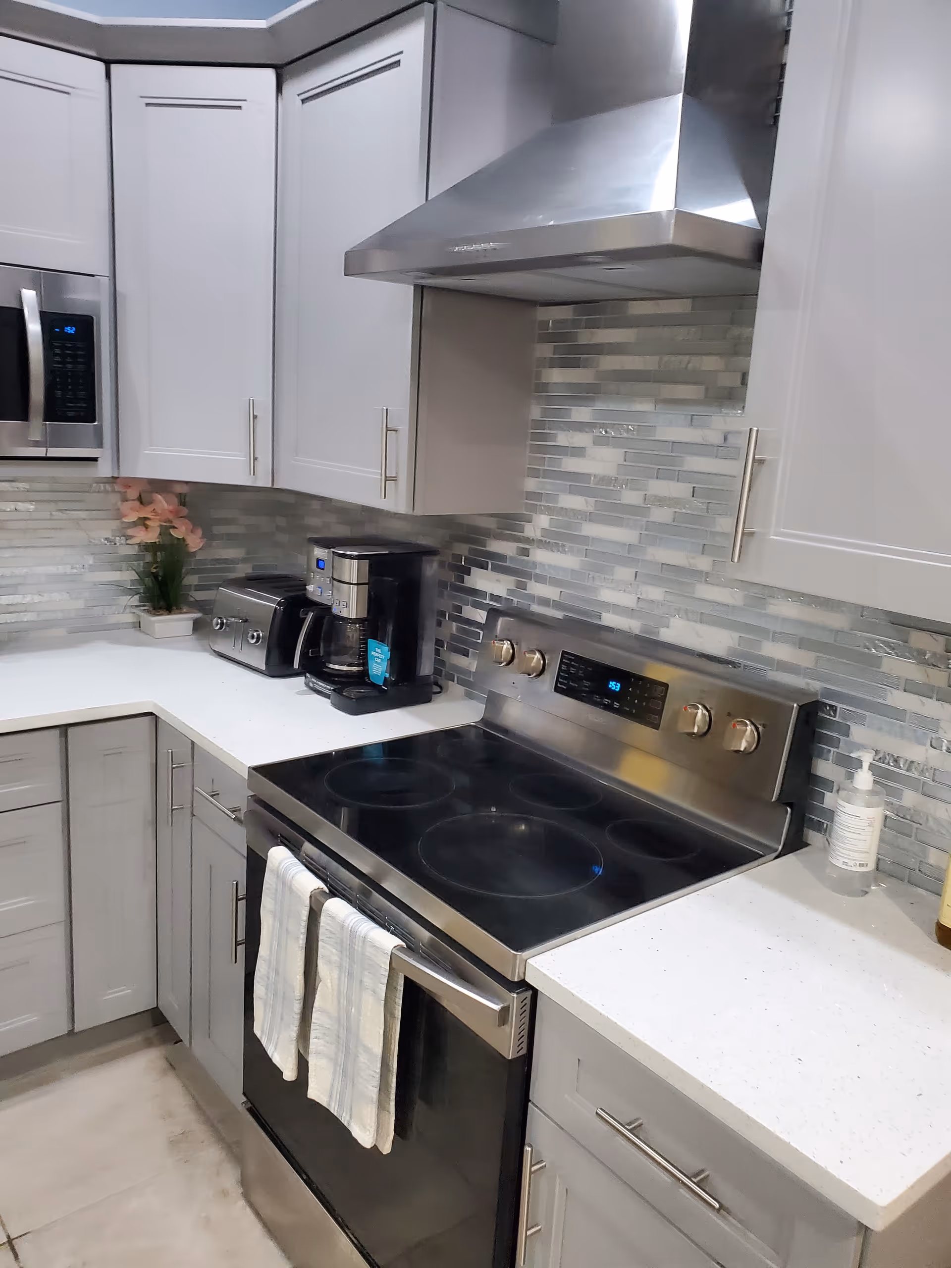 Modern kitchen in a senior living facility with stainless appliances and glass backsplash