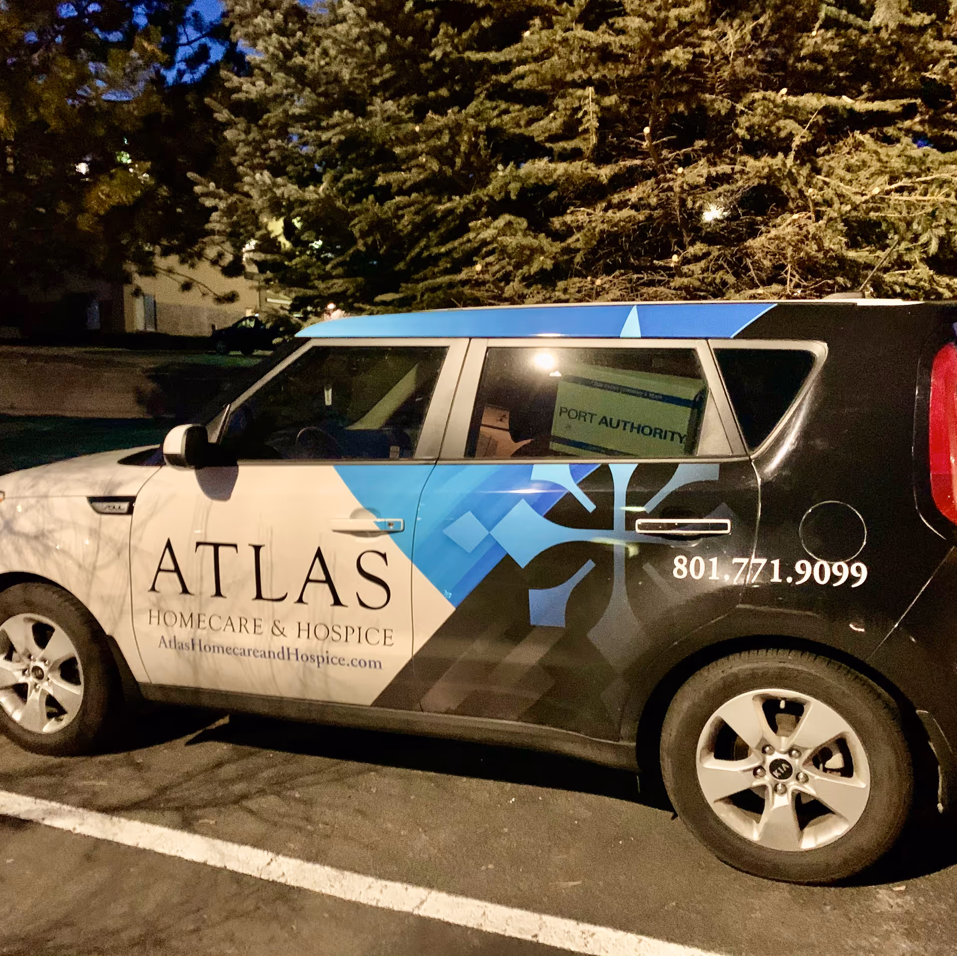A branded Atlas Homecare and Hospice van parked in a dimly lit lot.