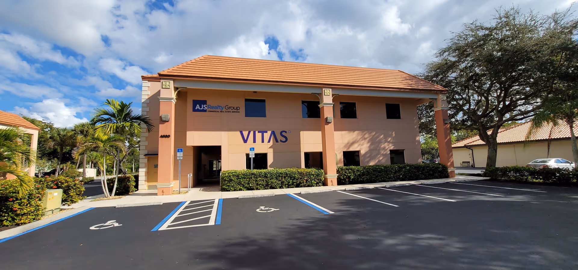 Front view of a VITAS healthcare building with parking lot and handicap spaces.
