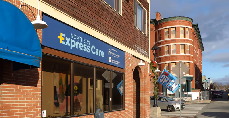 Brick storefront with Northern Express Care sign, blue canopy, and open storefront on the street.