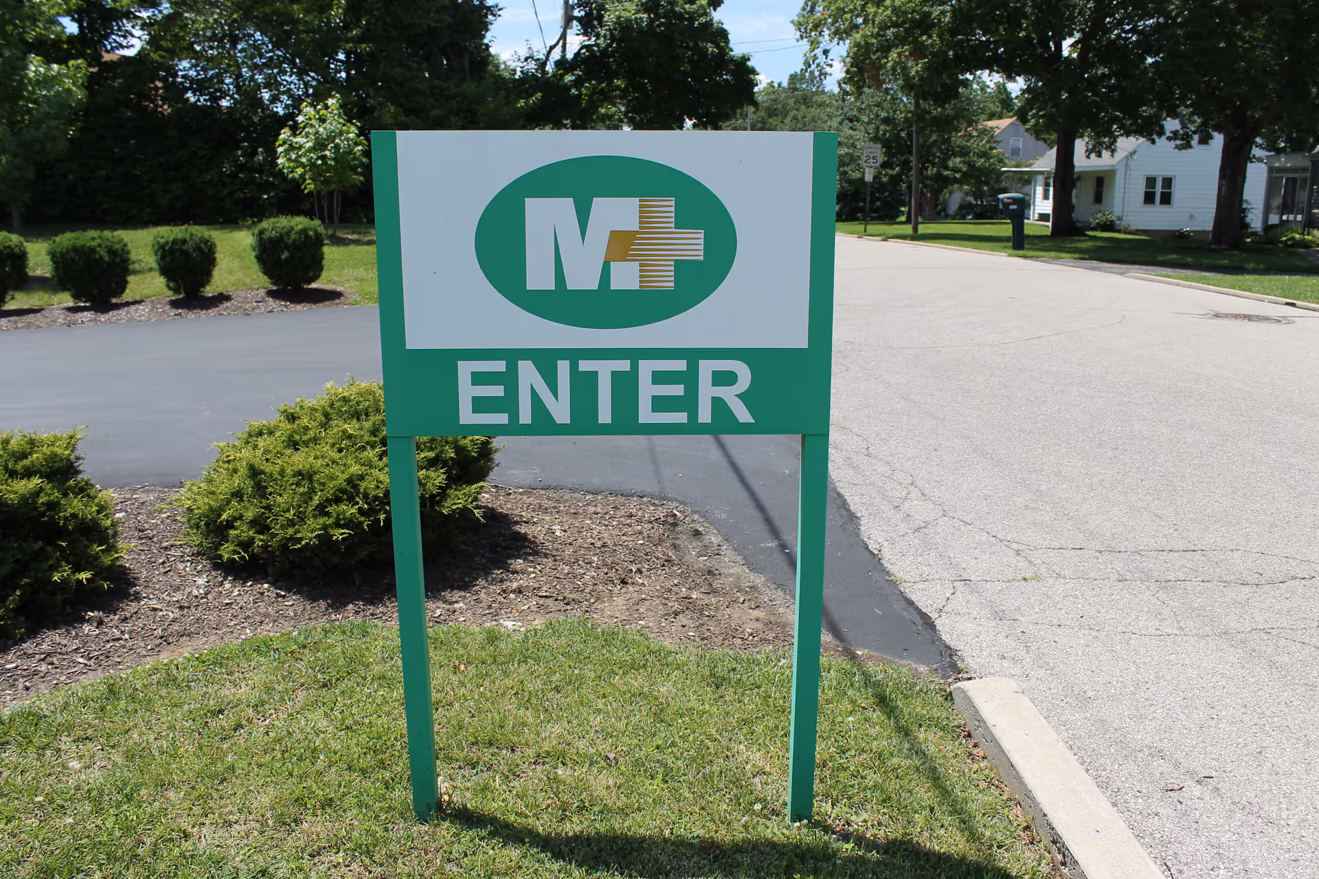 Green entrance sign for Mullaney's/JANZ Medical Supply outside a senior living facility.