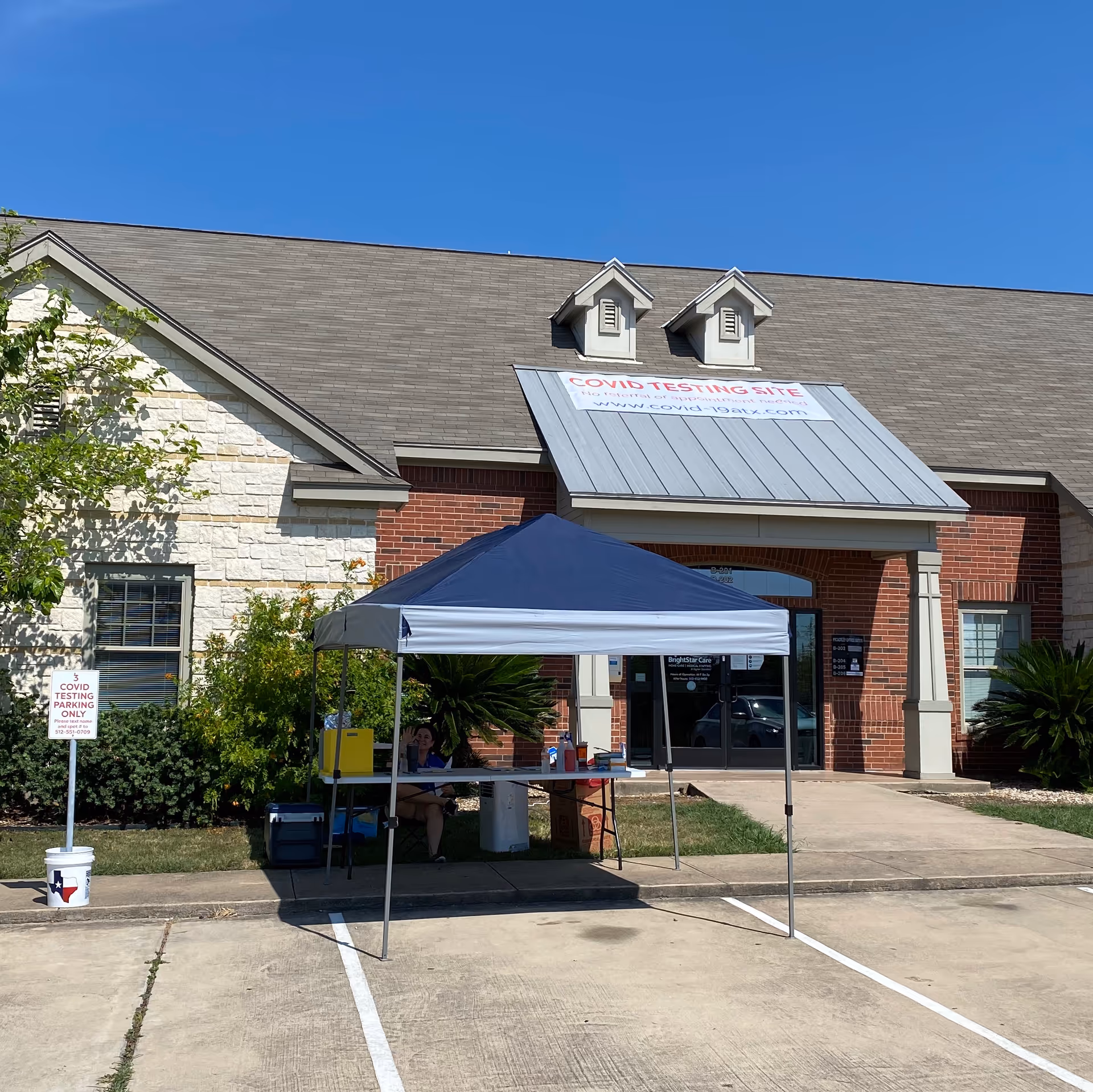 Front exterior of BrightStar Care building with a COVID testing tent out front