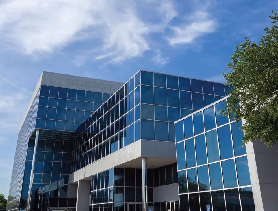 Cornerstone Caregiving facility exterior with blue glass facade and clear sky.