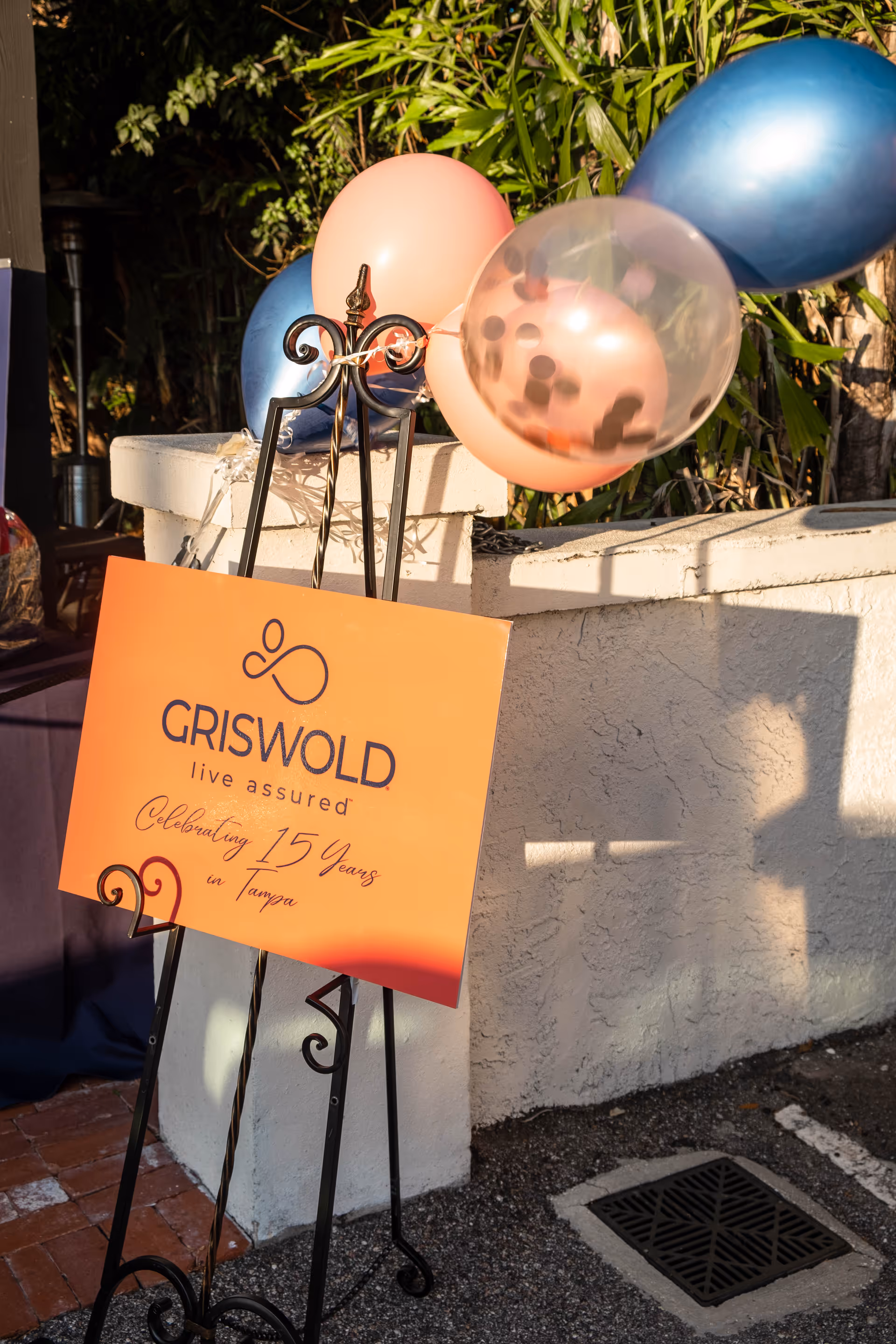 Griswold sign with balloons outdoors beside a white stucco wall