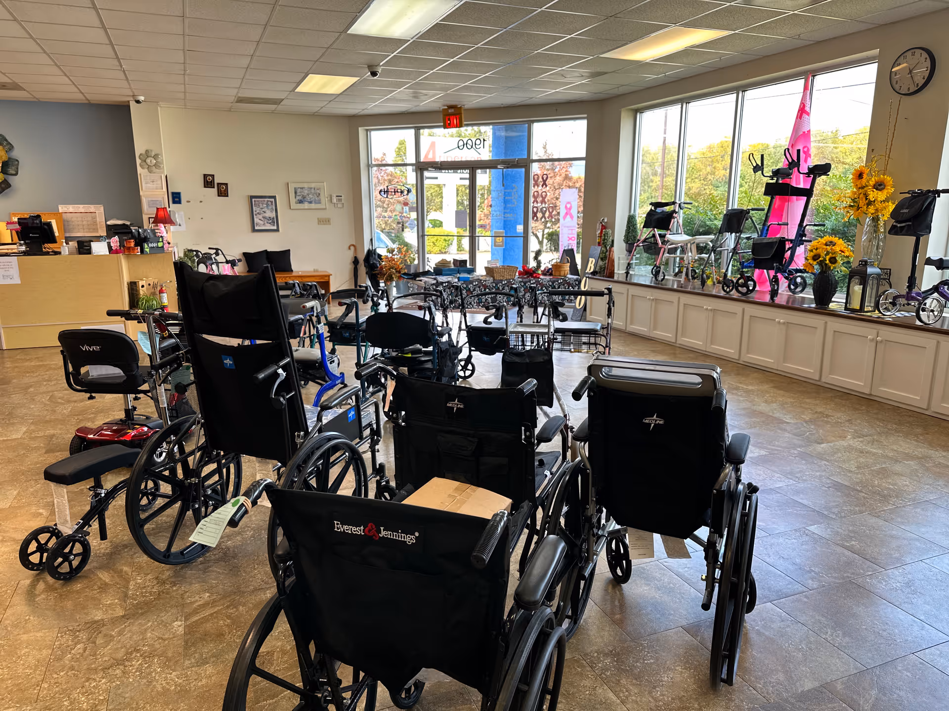 Lobby interior filled with wheelchairs and mobility aids near large windows.