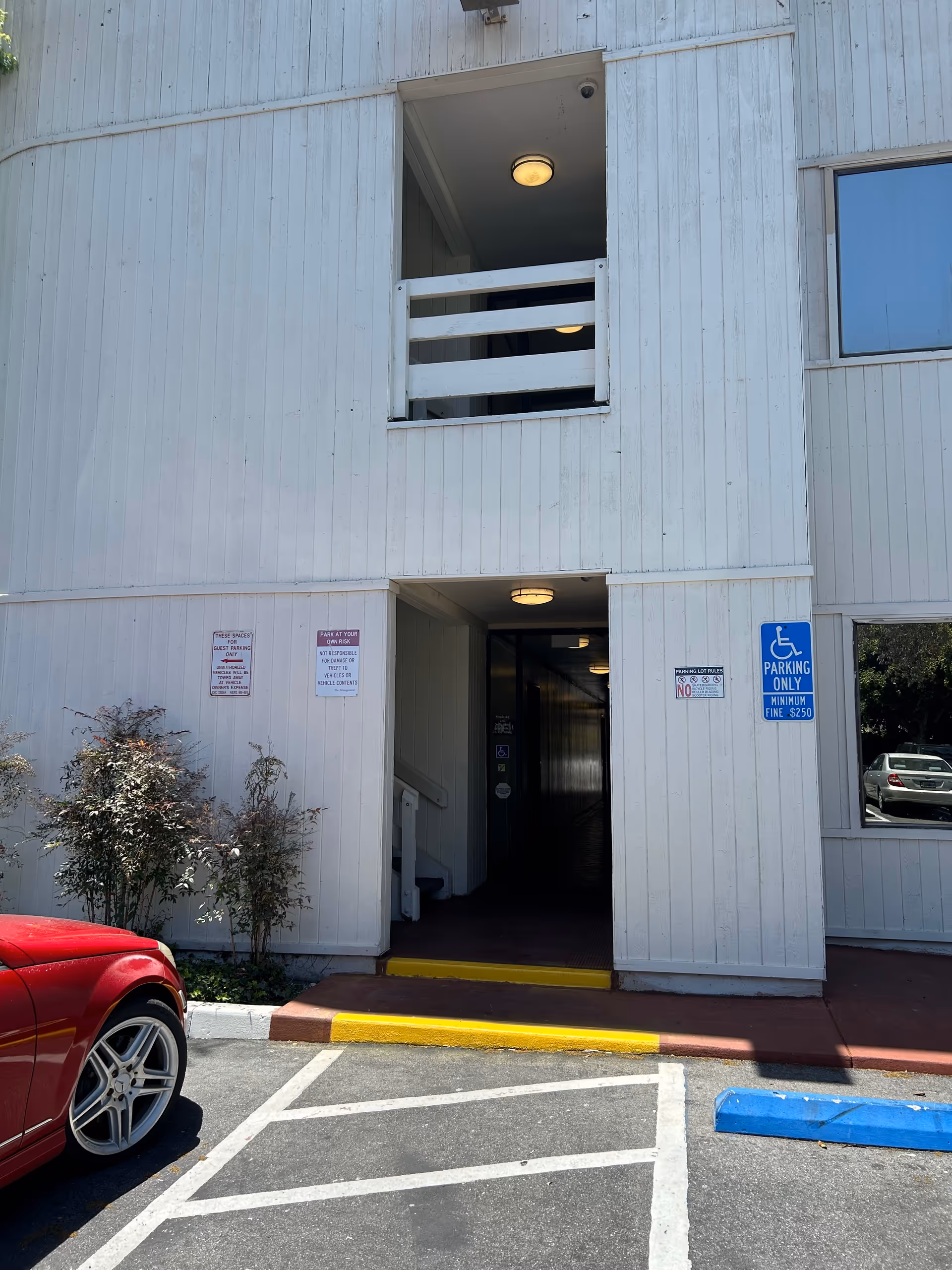 Exterior of a senior care facility with an open entrance and parking signs.