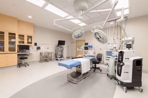Modern operating room at Plymouth Orthopedic Surgery Center with surgical lights and patient bed.