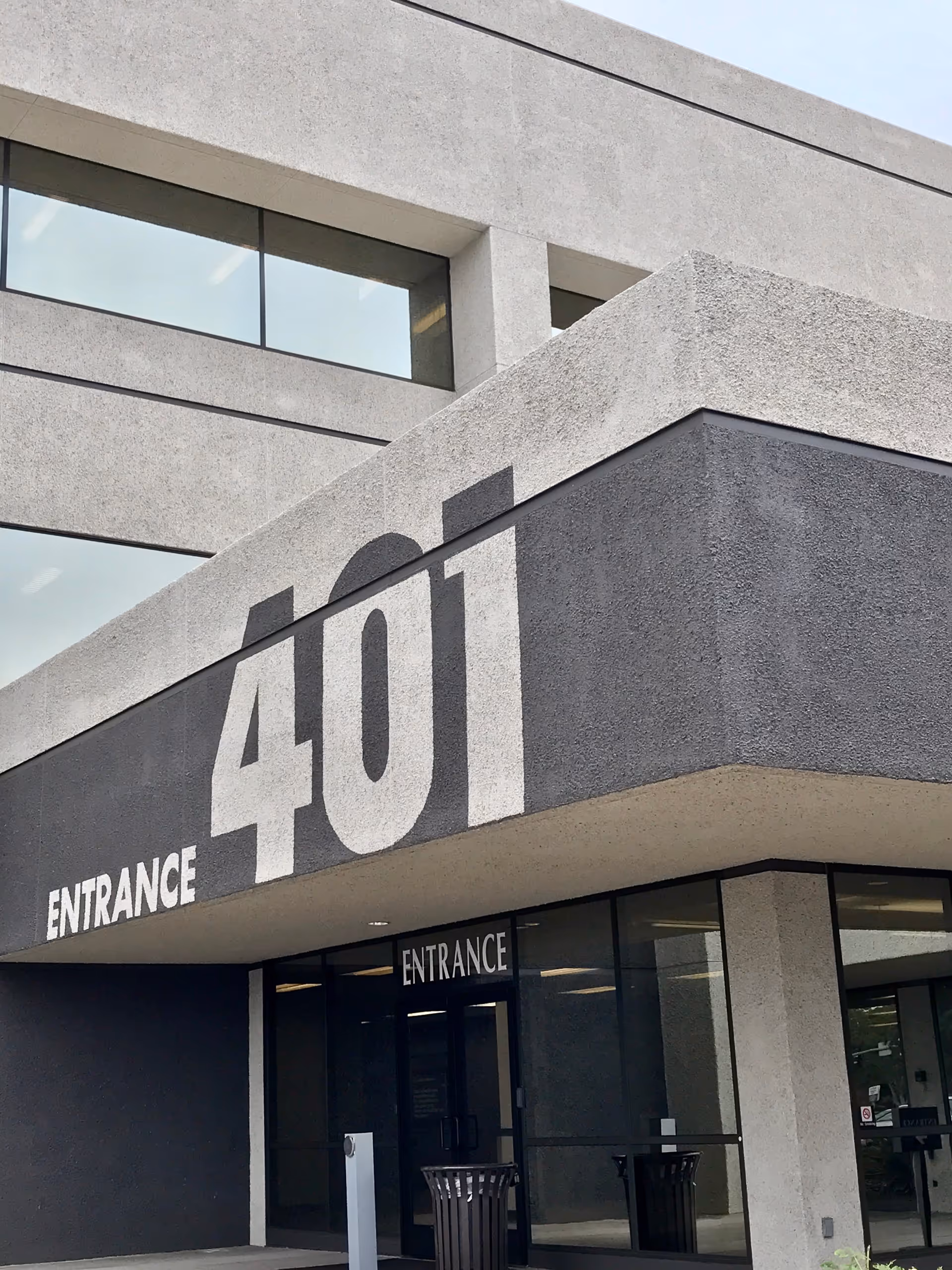 Front exterior of a concrete building with a large '401' entrance sign.