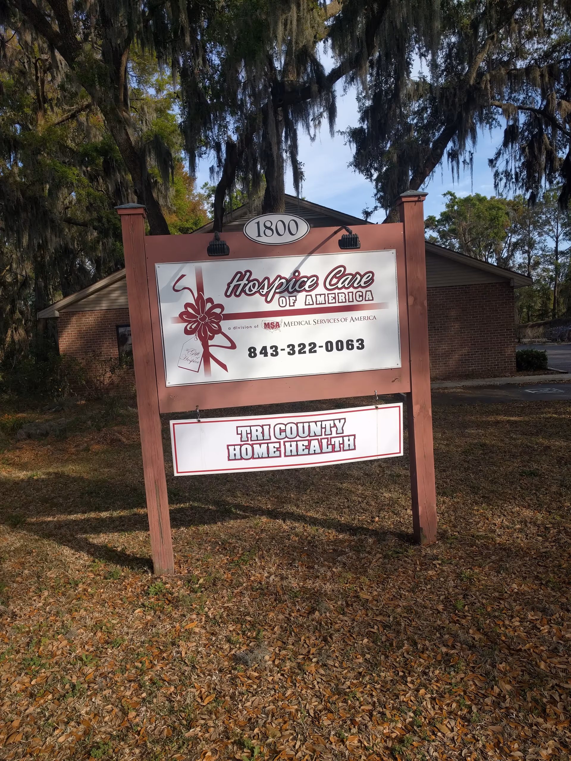 Sign for Hospice Care of America and Tri County Home Health in front of brick building