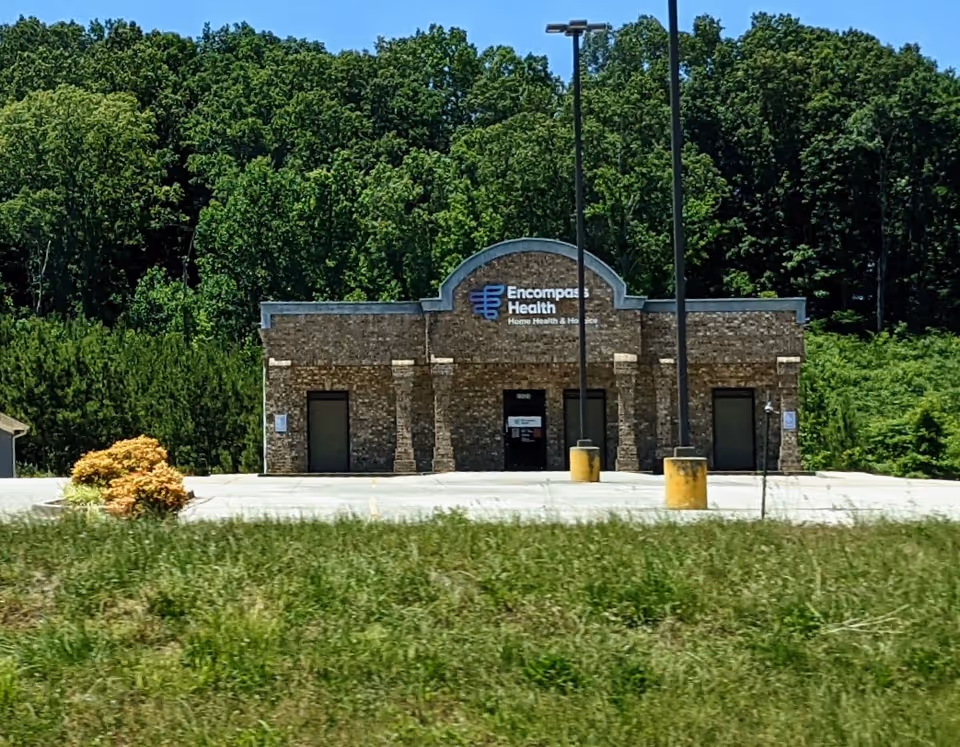 Brick building with Encompass Health sign sits in a paved parking lot