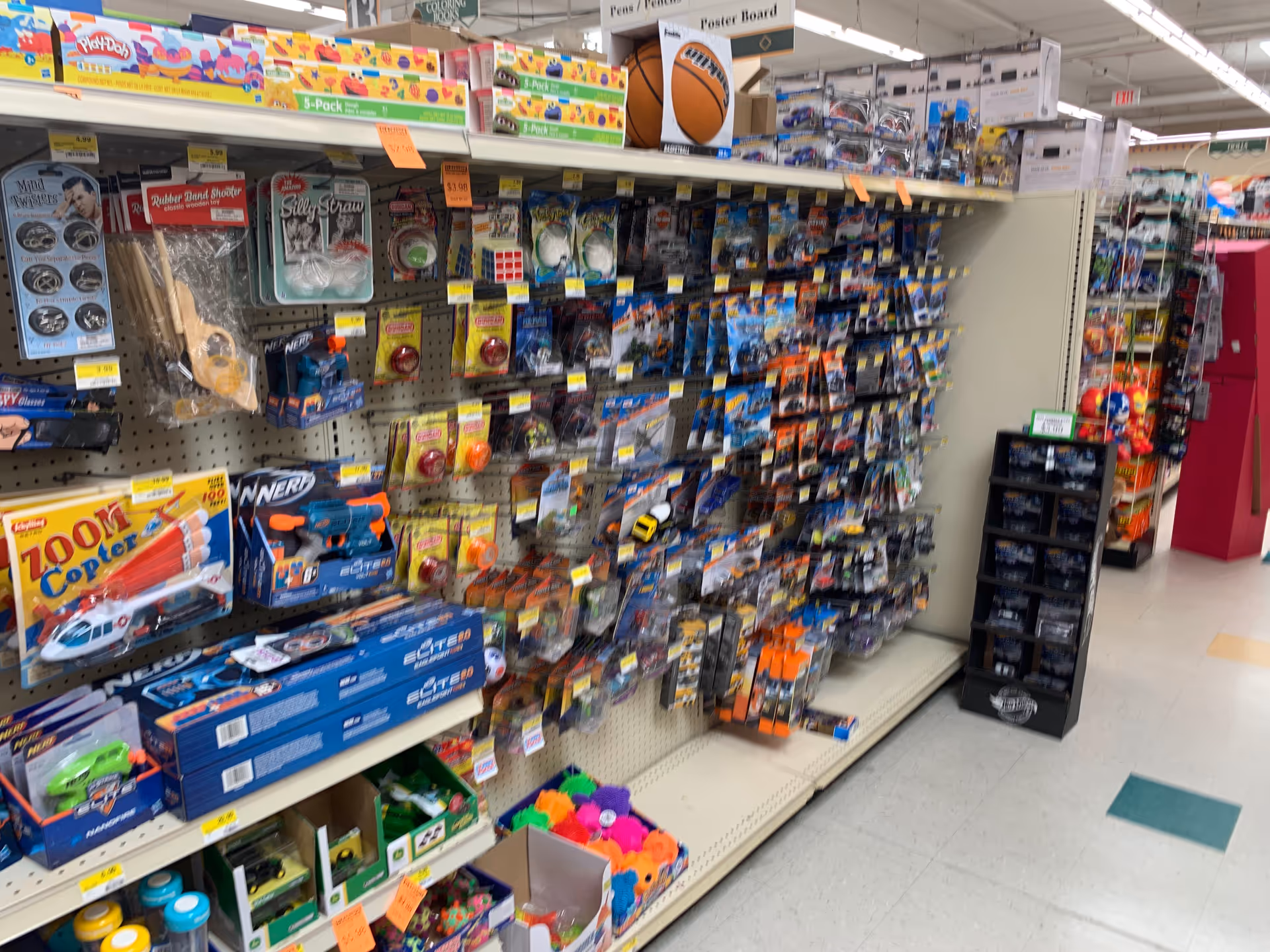 Aisle inside a drugstore filled with colorful toy packaging.