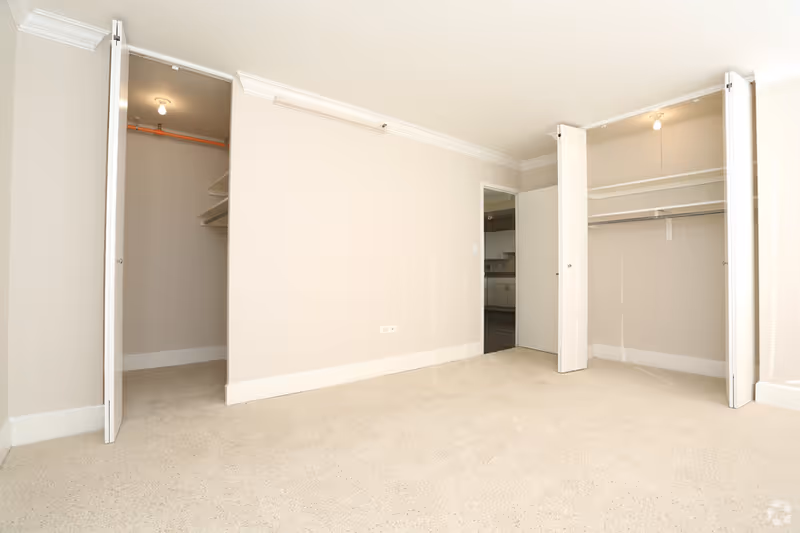Empty bedroom with open closets in a senior living facility.