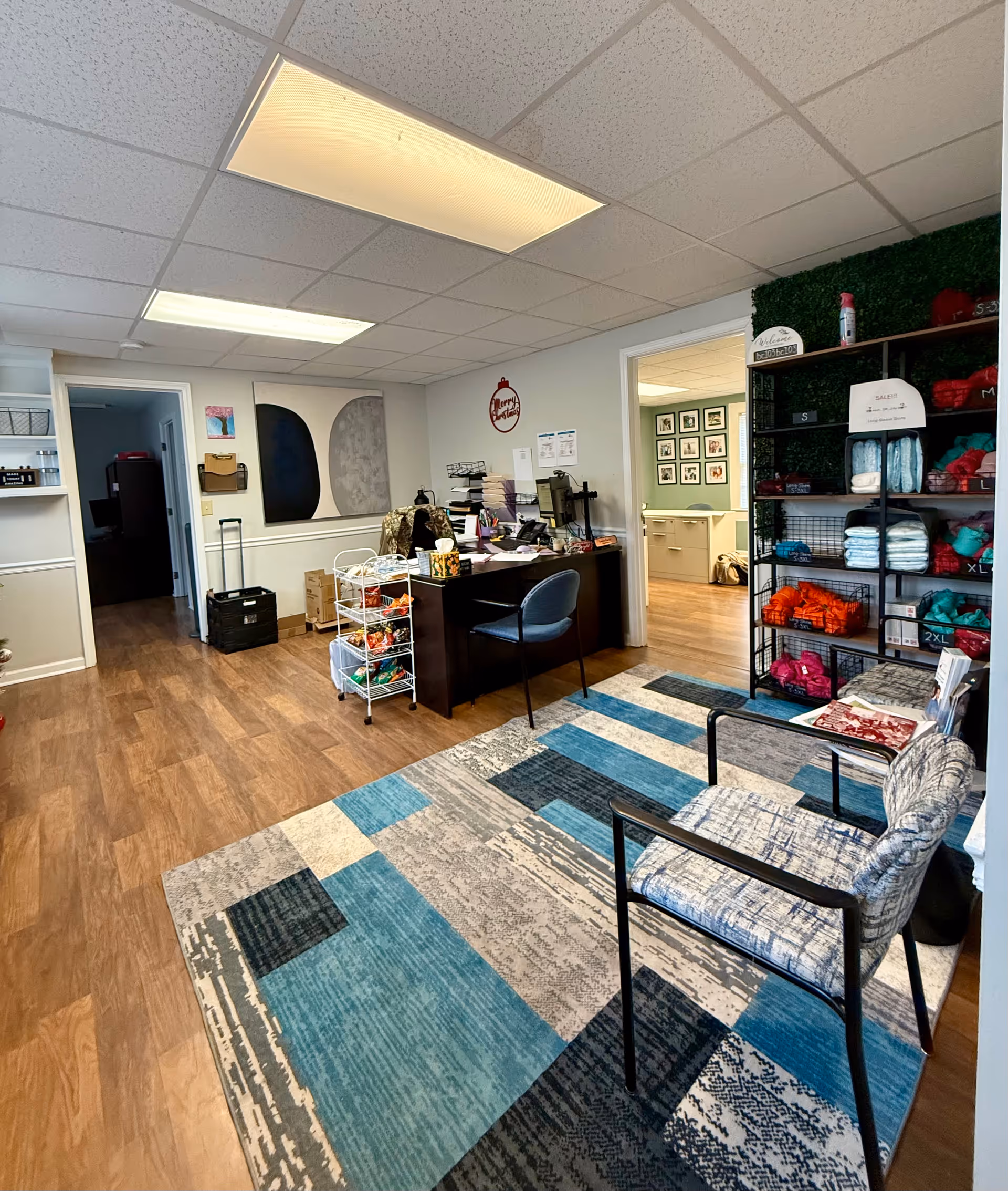 Reception area with desk, seating, and organized shelves in a senior living lobby.