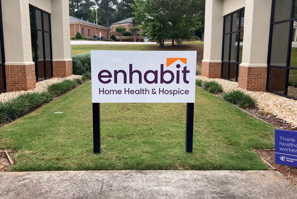 Enhabit Home Health & Hospice sign posted outside a building front on grass.
