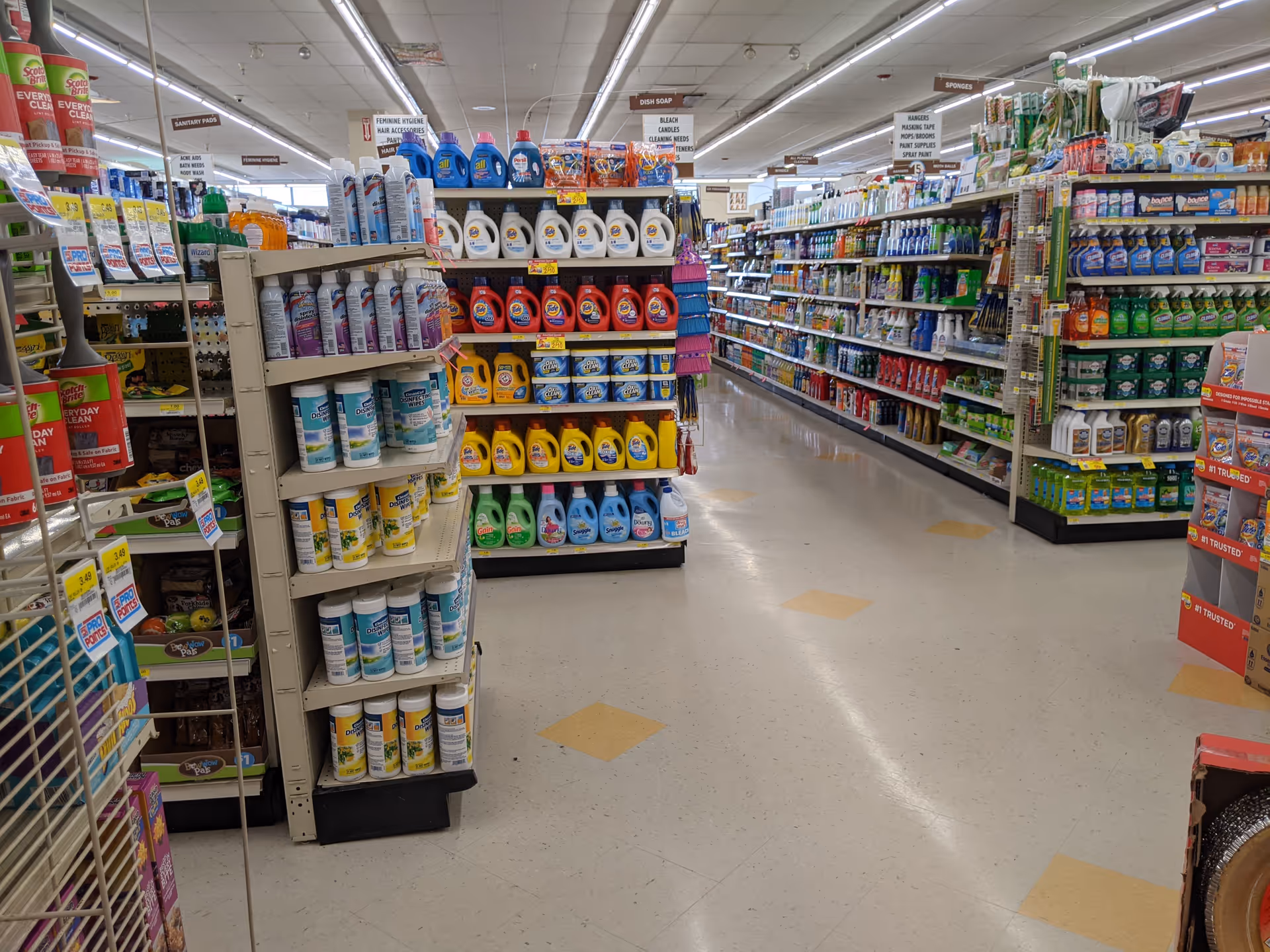 Interior view of a drugstore aisle with cleaning products on shelves.