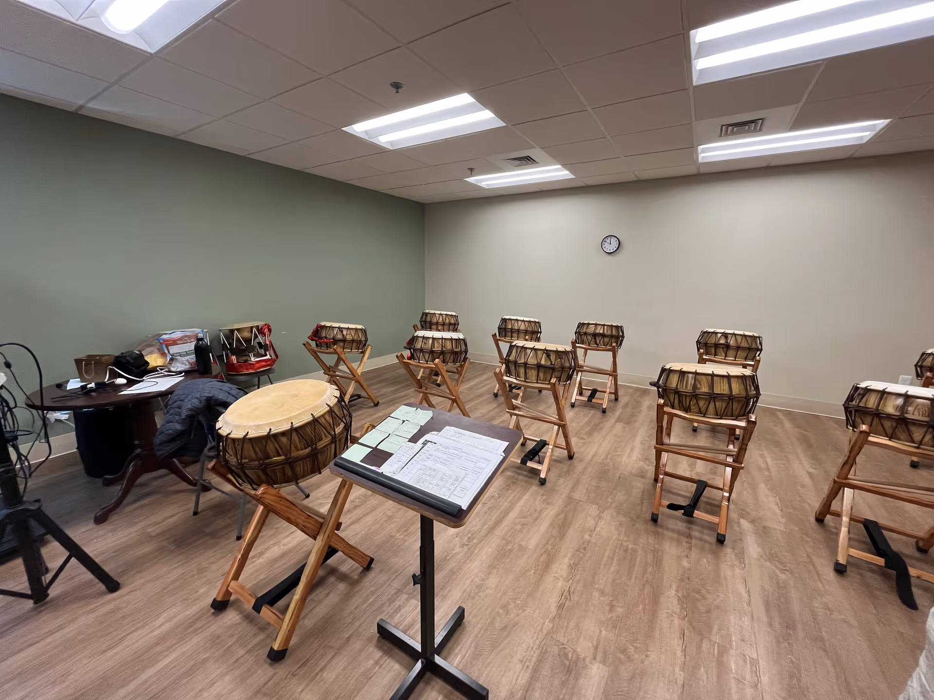 Music room with many drums on stands and a sheet music stand.