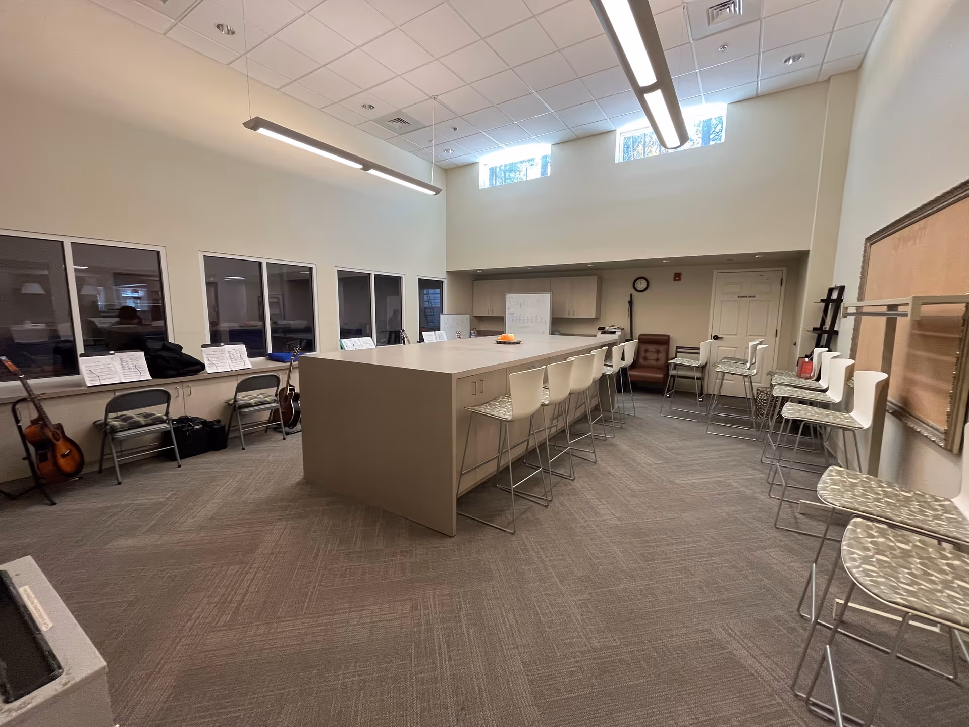 Interior activity room at Lifecare Partners with a central island, stools, and guitars.