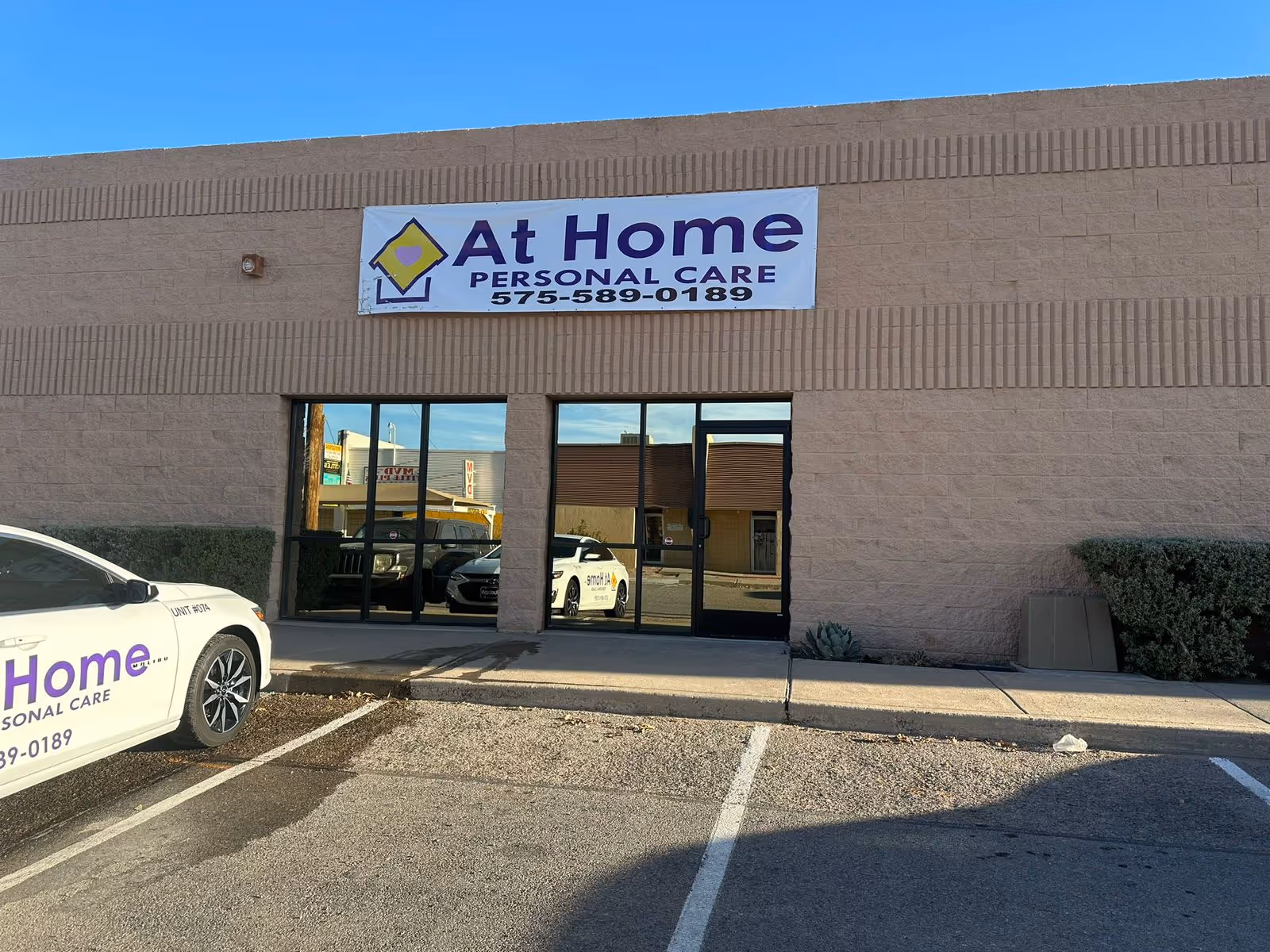 Exterior view of a beige brick building with an At Home Personal Care banner.
