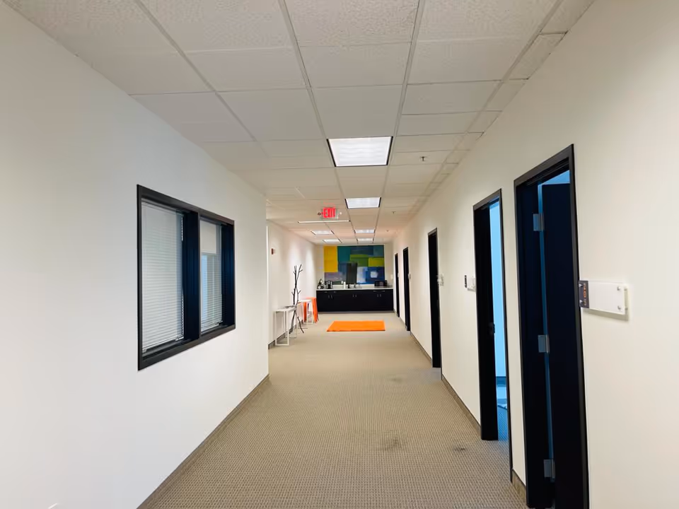 Interior hallway of Serengeti Care facility, doors on both sides and a reception area at end.
