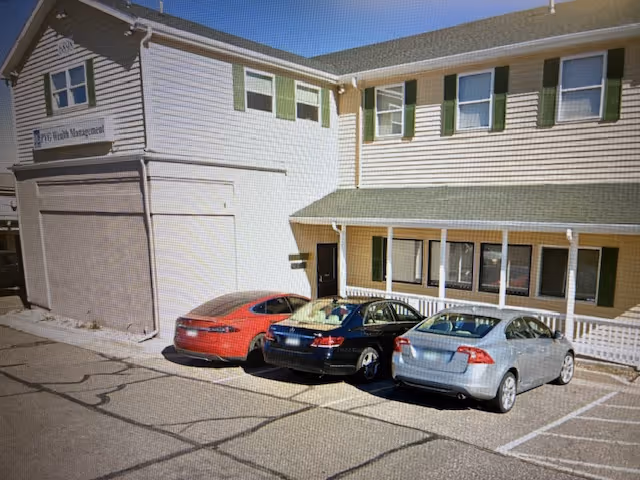 Exterior view of Comfort Keepers Home Care building with three parked cars.