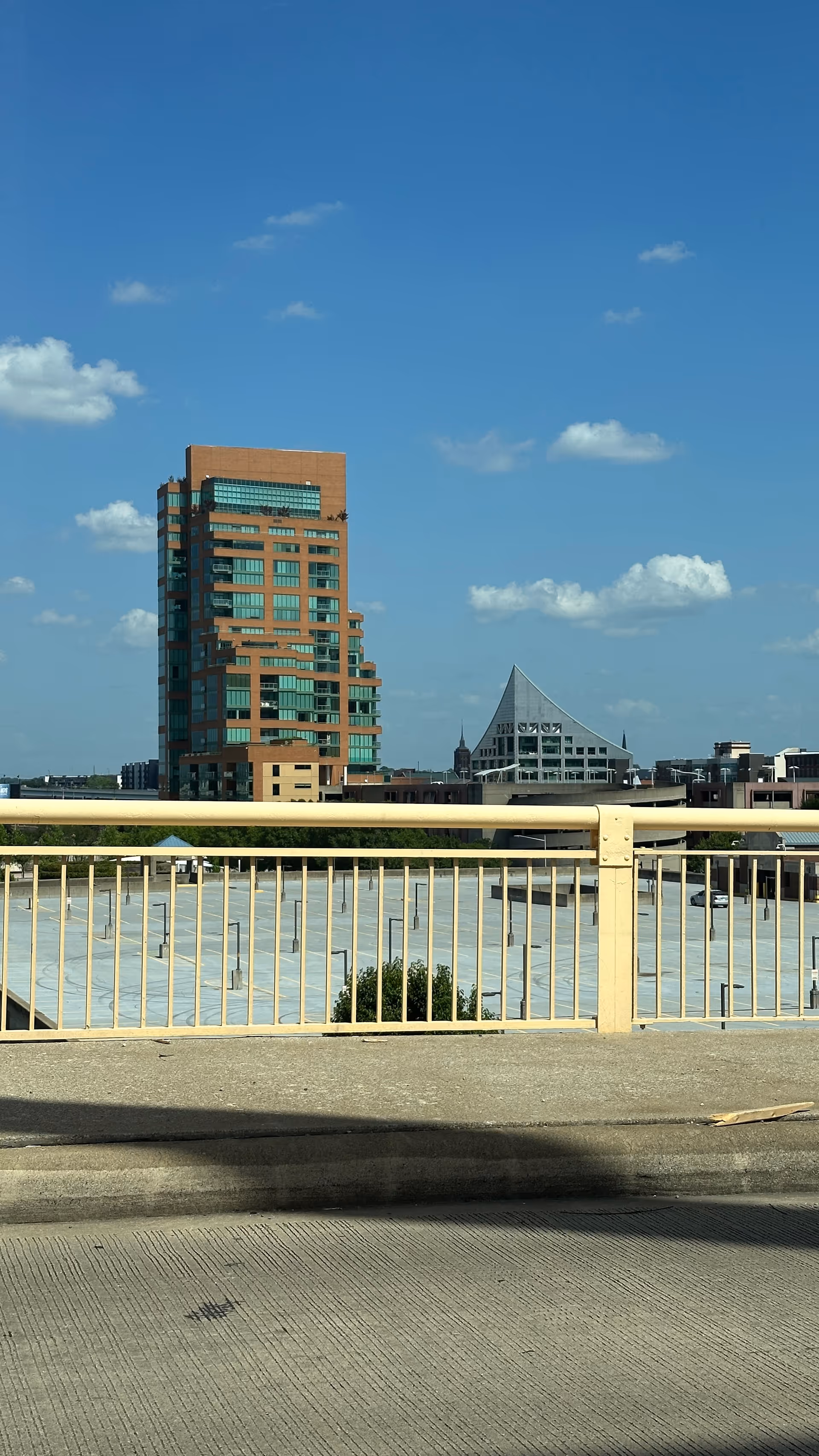 City skyline with modern buildings seen from a railing on a sunny day
