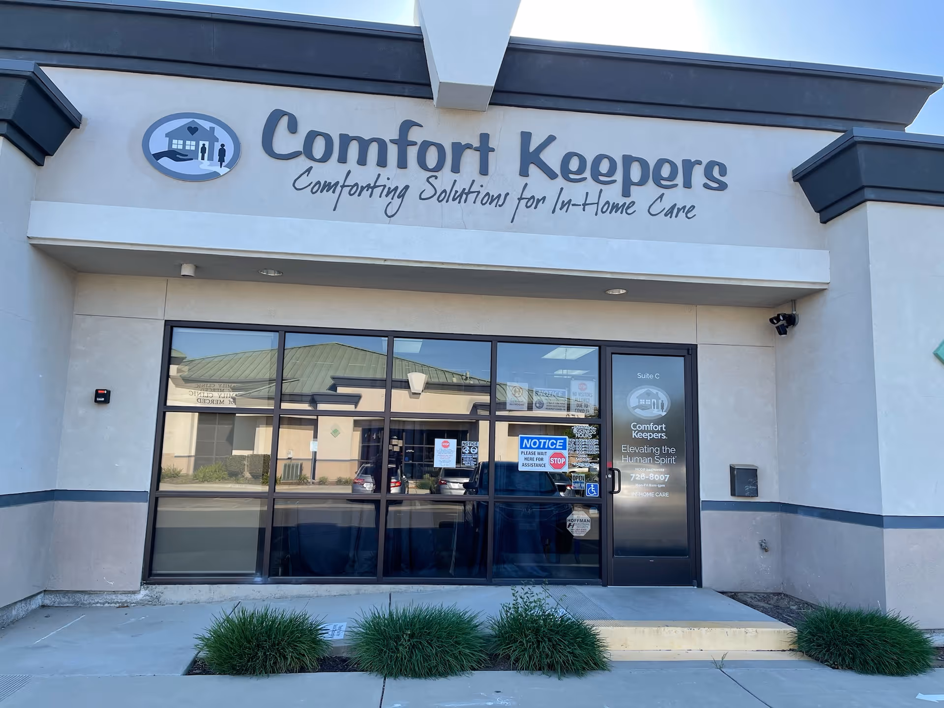 Exterior view of Comfort Keepers Home Care storefront with logo and glass doors.