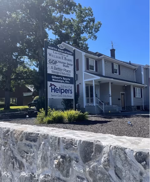 Two-story gray building with a signboard for Senior Helpers of Metrowest.