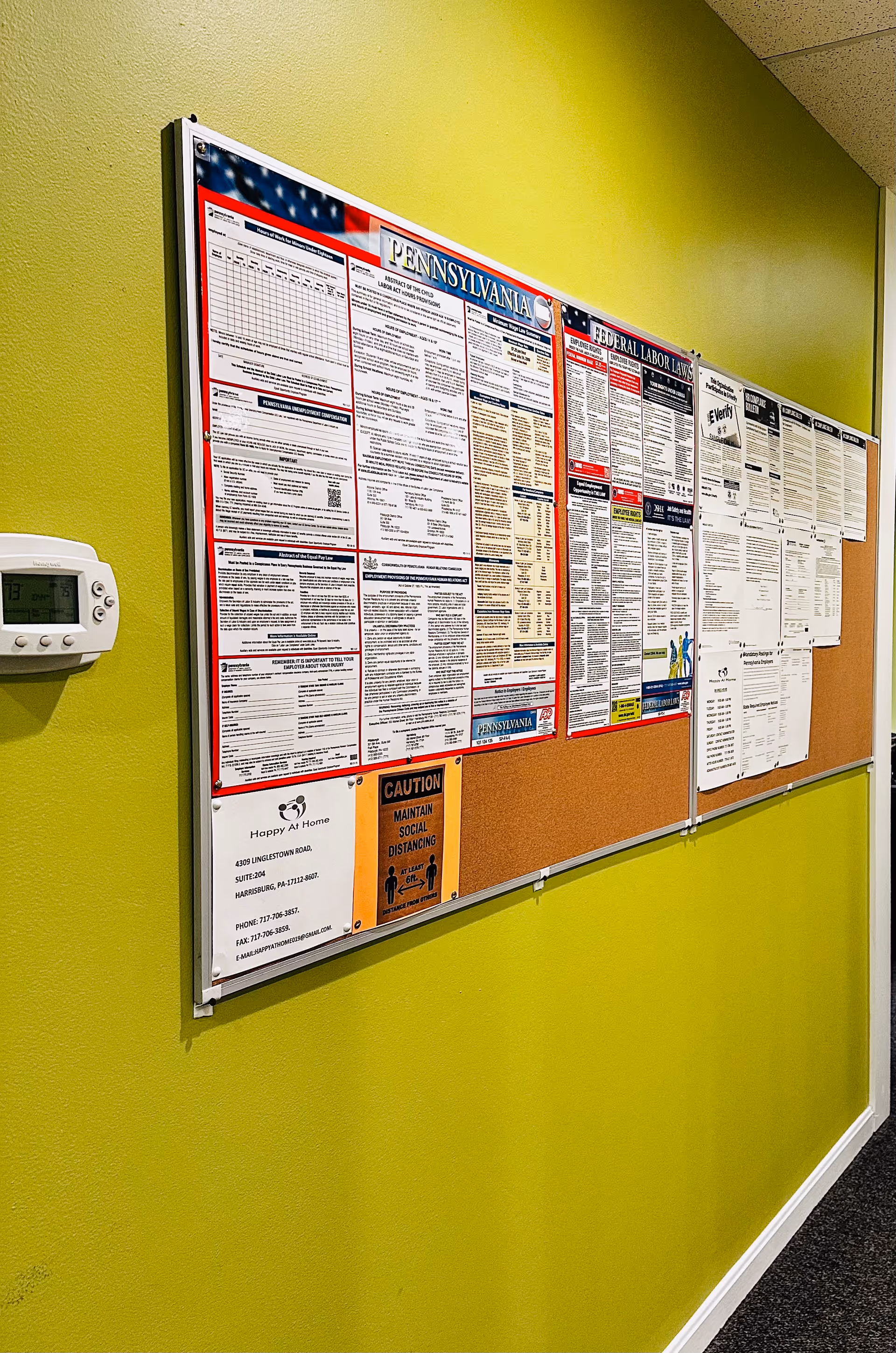 Bright lime-green hallway with a large bulletin board of notices.