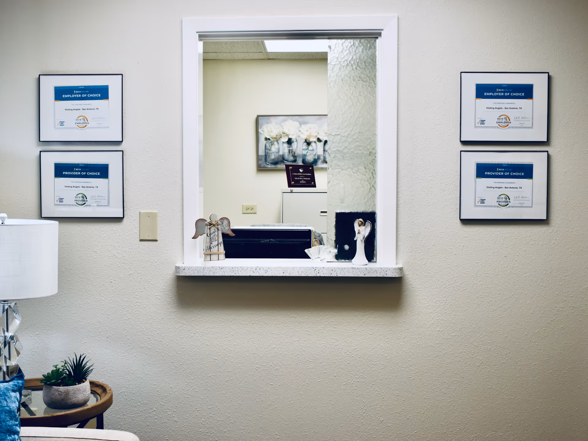 Reception window in a senior care facility with framed certificates on the walls.