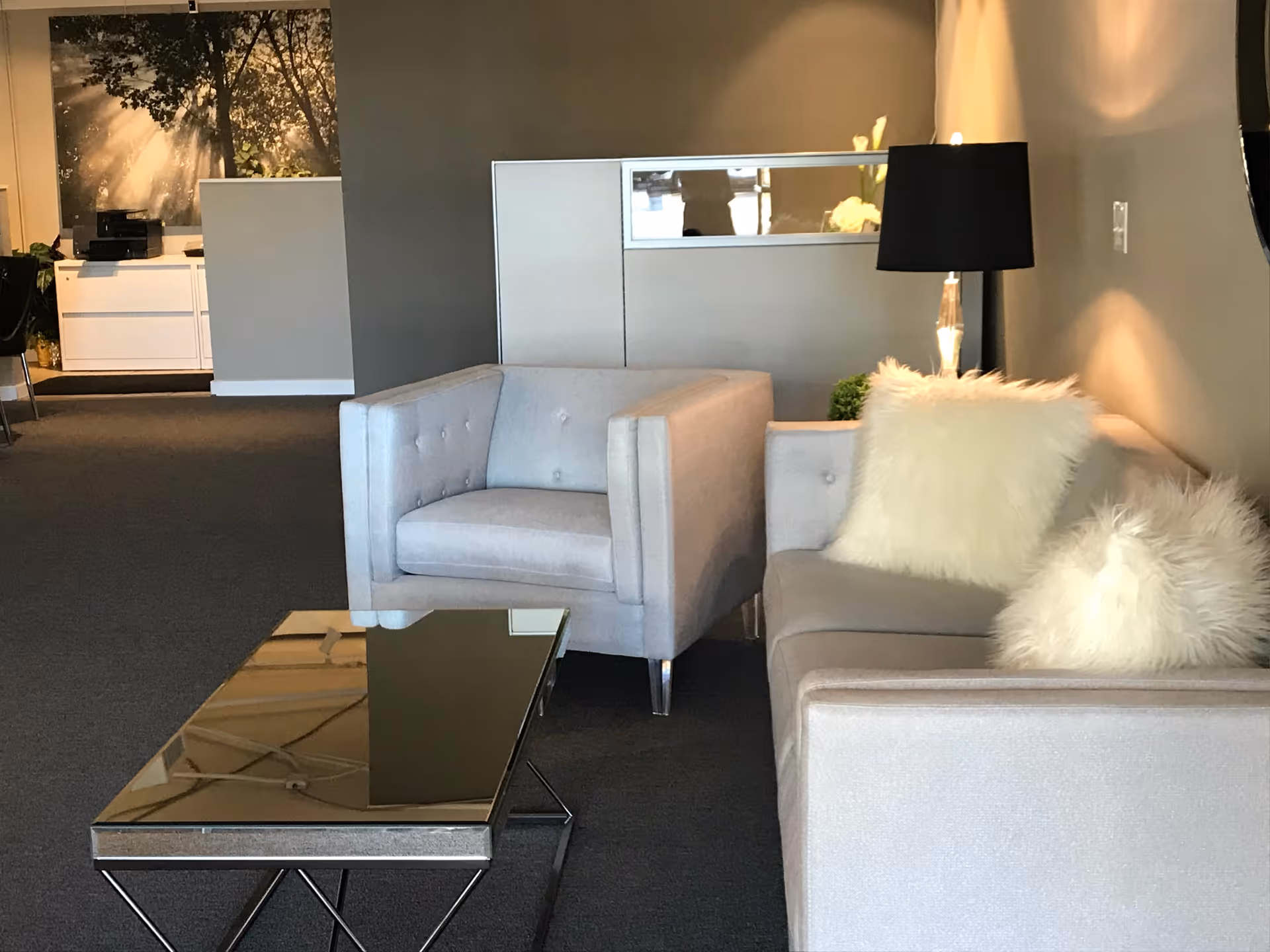 Modern gray lounge area with sofas, pillows, coffee table, and a floor lamp.