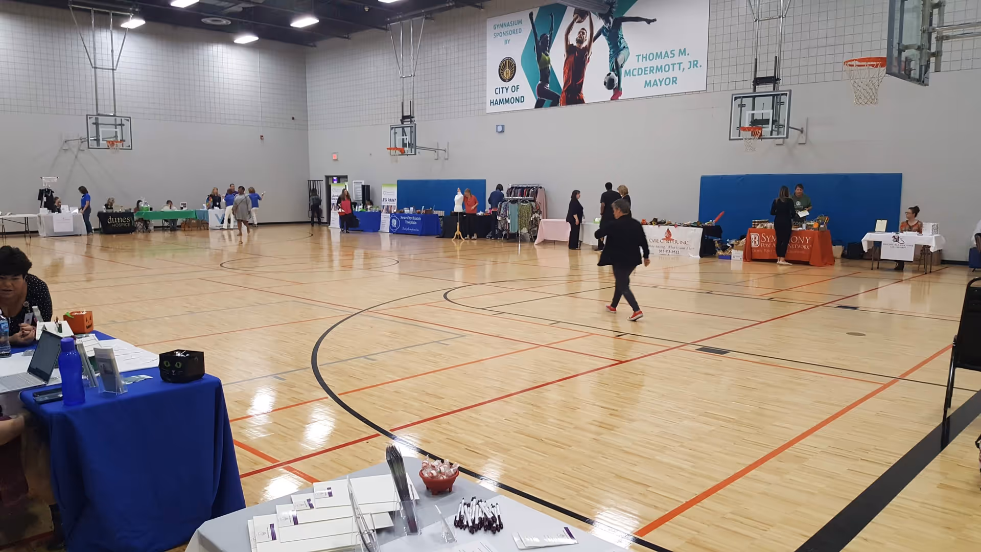 Indoor gymnasium at Carters Care Services hosting vendor tables along the basketball court.