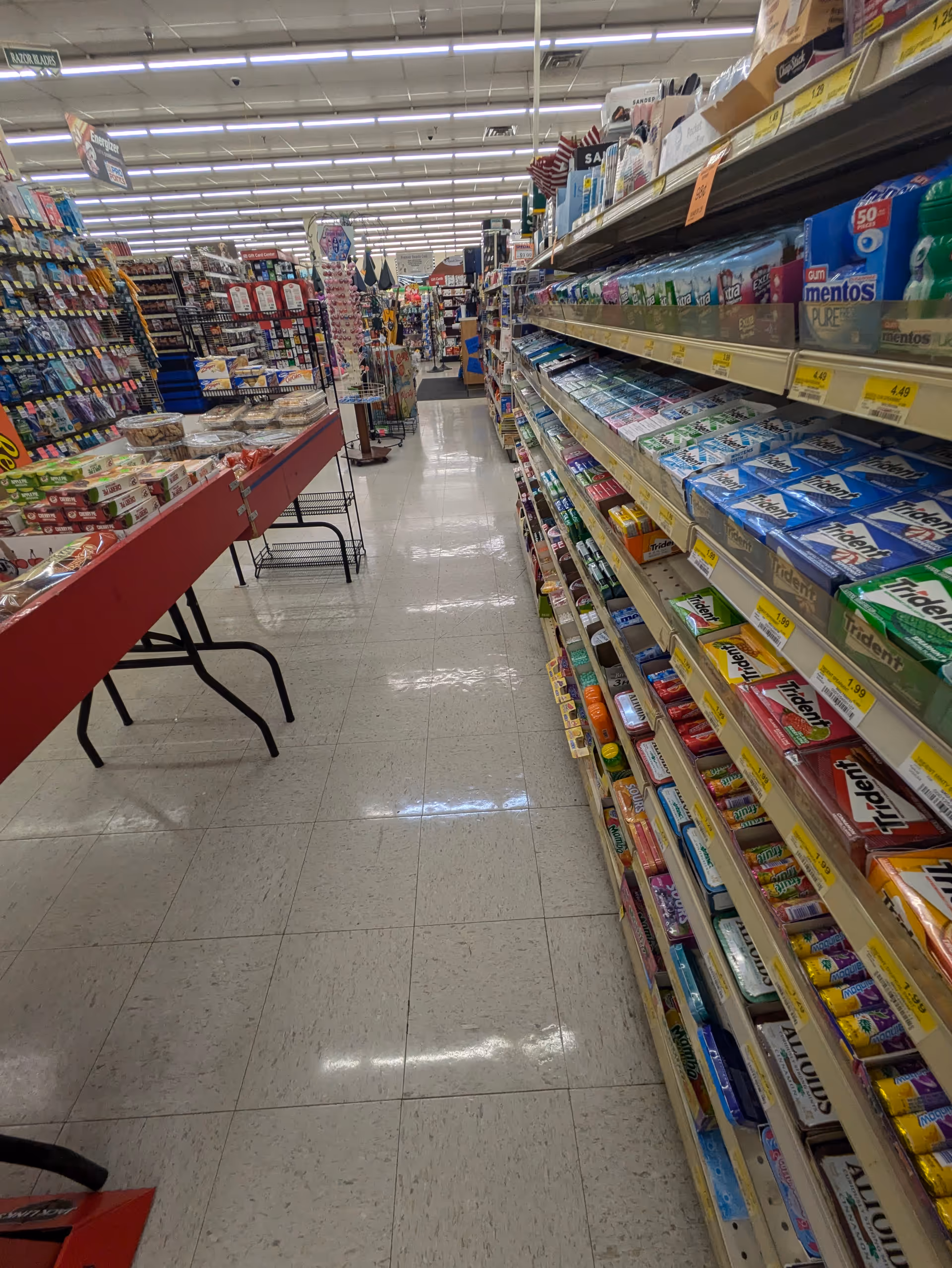 Aisle inside Discount Drug Mart with tall shelves of toothpaste and daily goods.