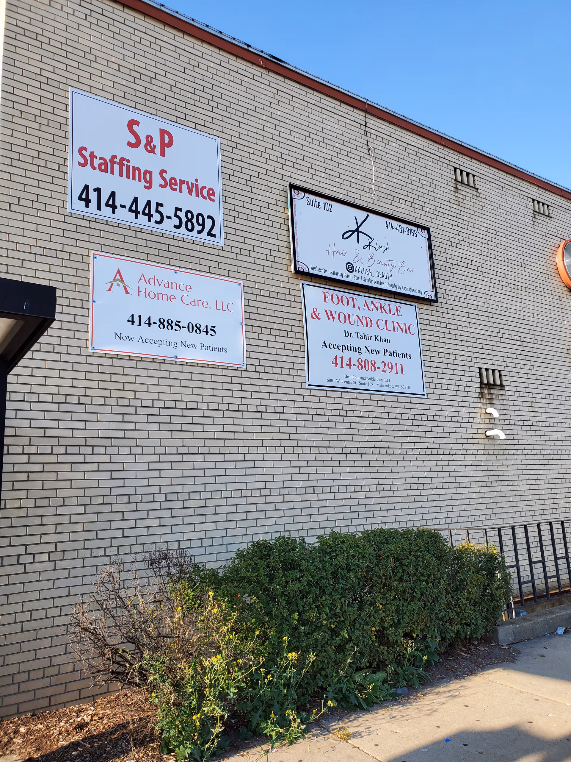 Brick exterior wall displaying several business signs including Advance Home Care LLC