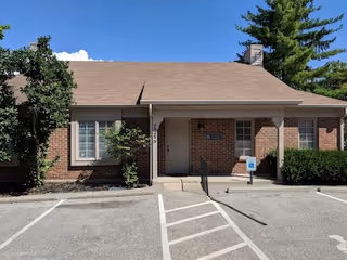 Brick senior living facility entrance with parking lot and handicap accessible sign.