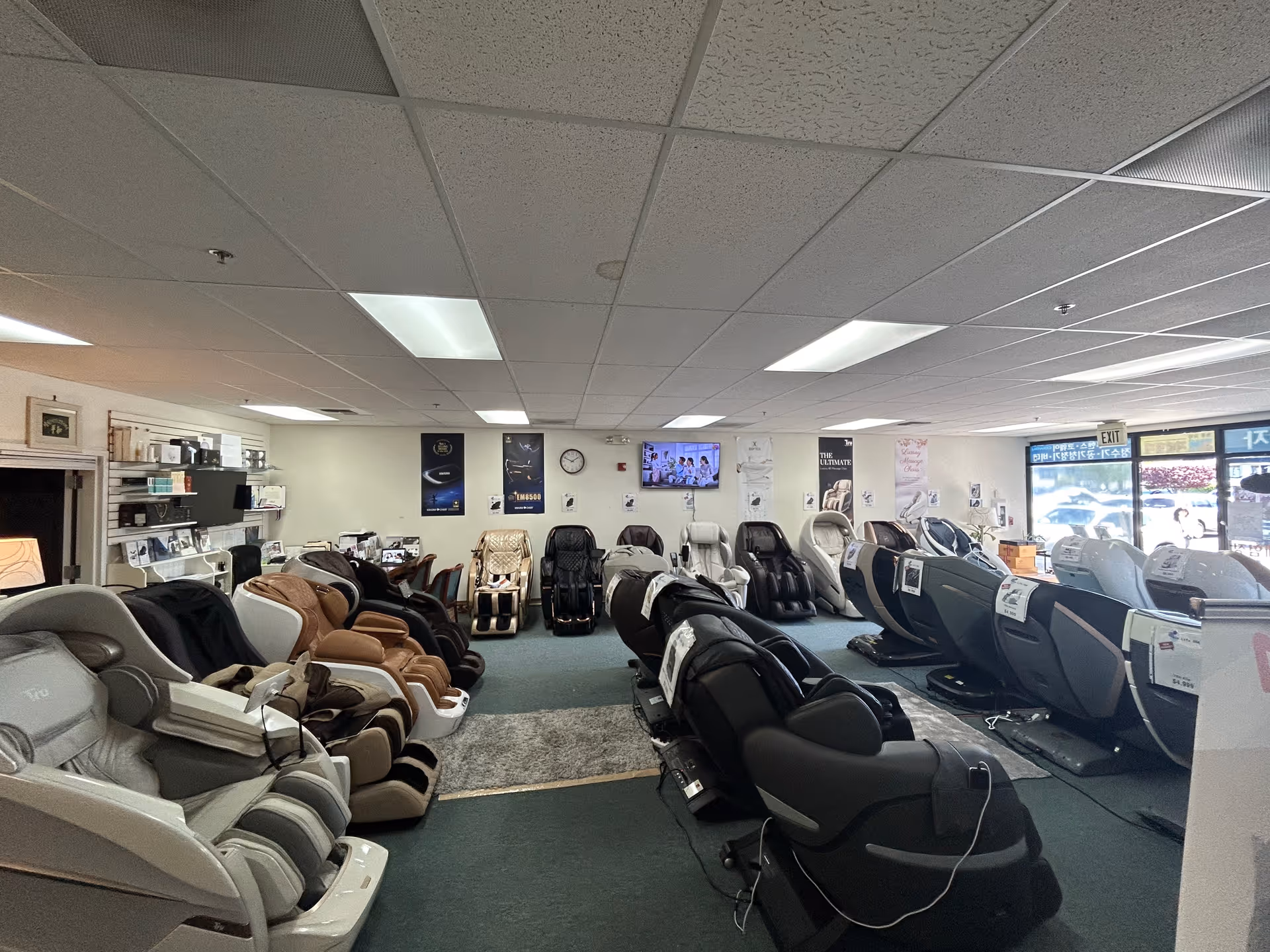Rows of massage chairs line the interior showroom, with posters and shelves along the walls.