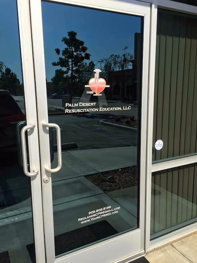 Glass storefront door displaying Palm Desert Resuscitation Education signage and logo.