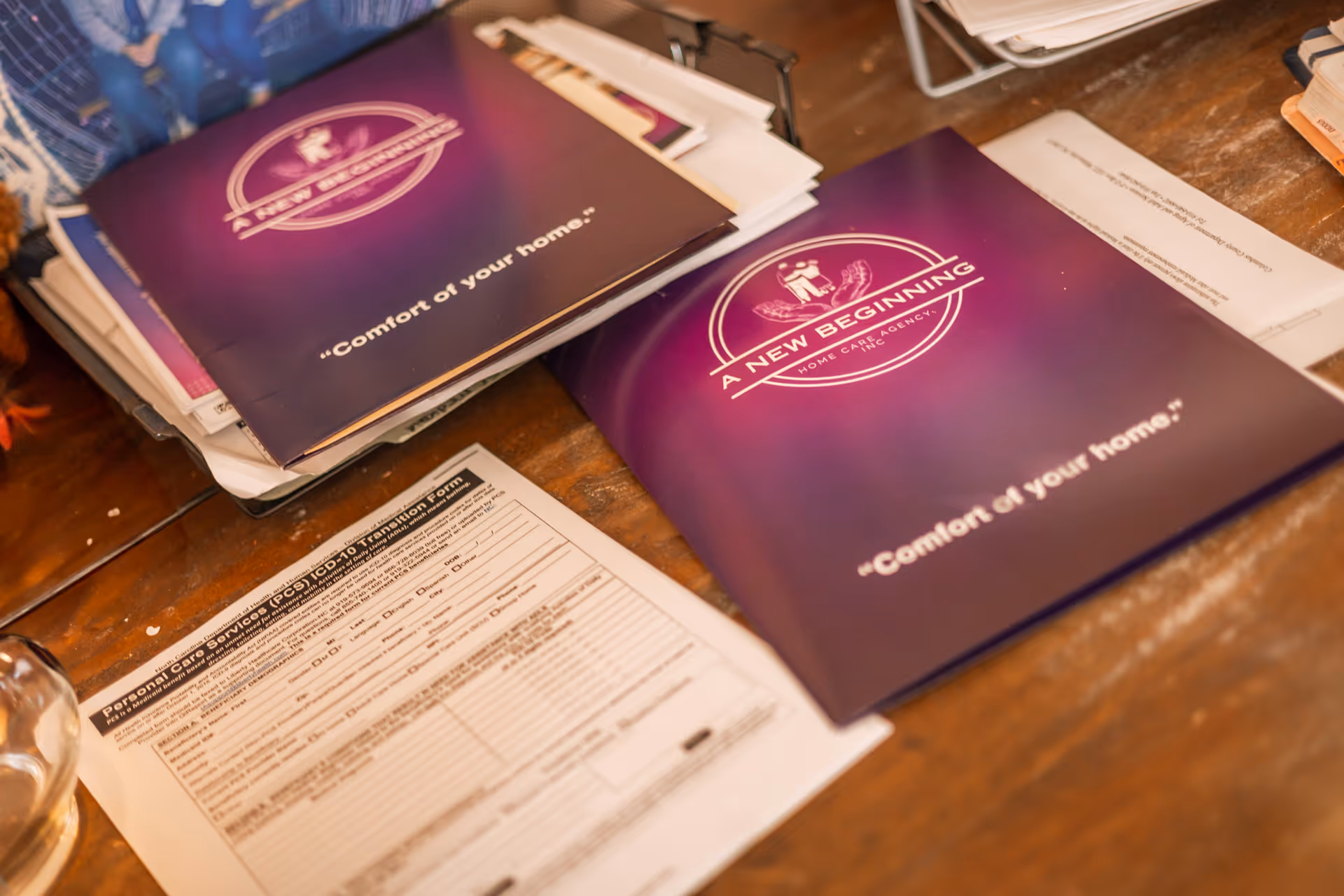 Purple brochures for A New Beginning Home Care Agency on a wooden desk