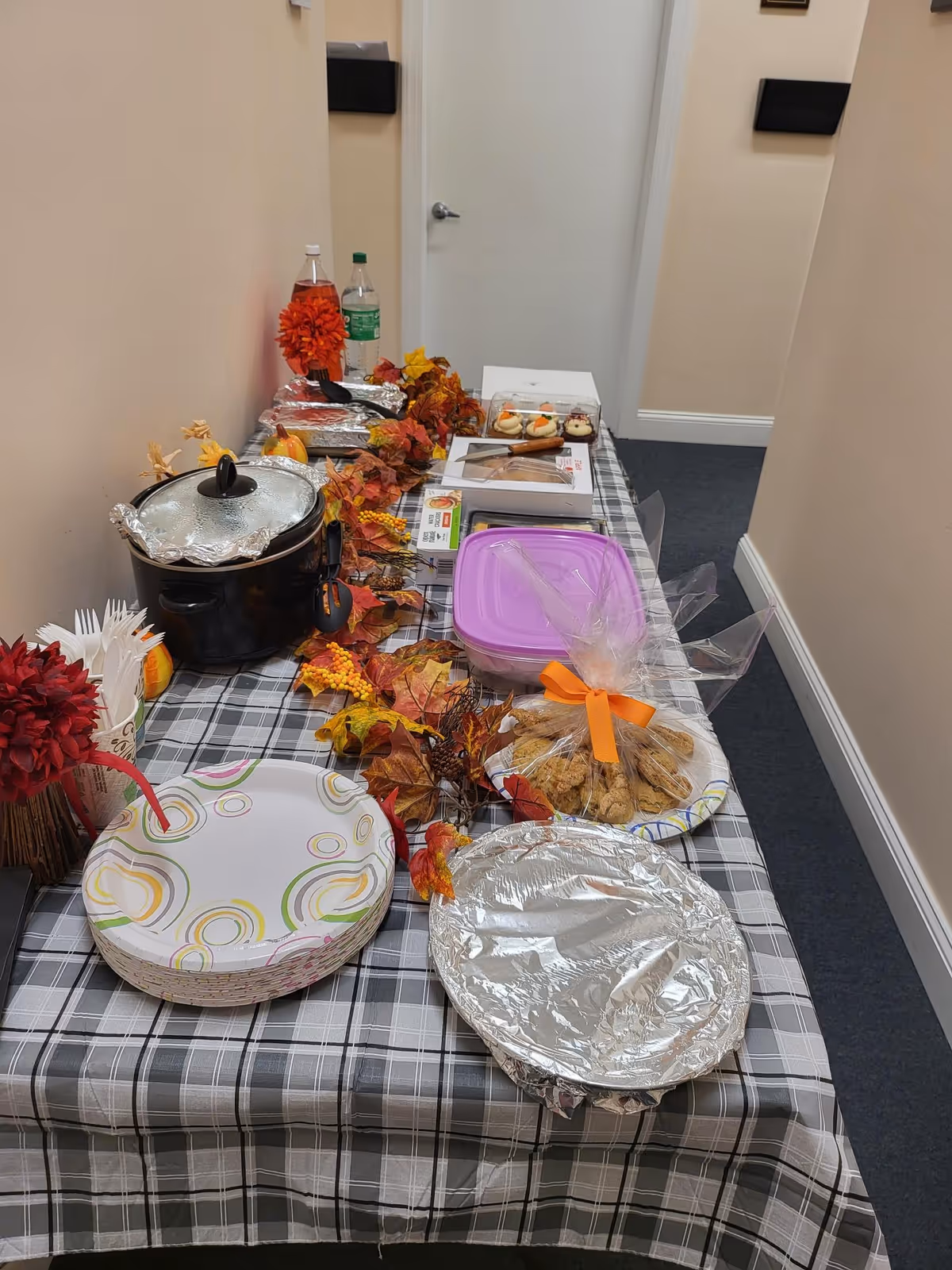 A hallway buffet table with autumn decor and snacks inside a senior home.