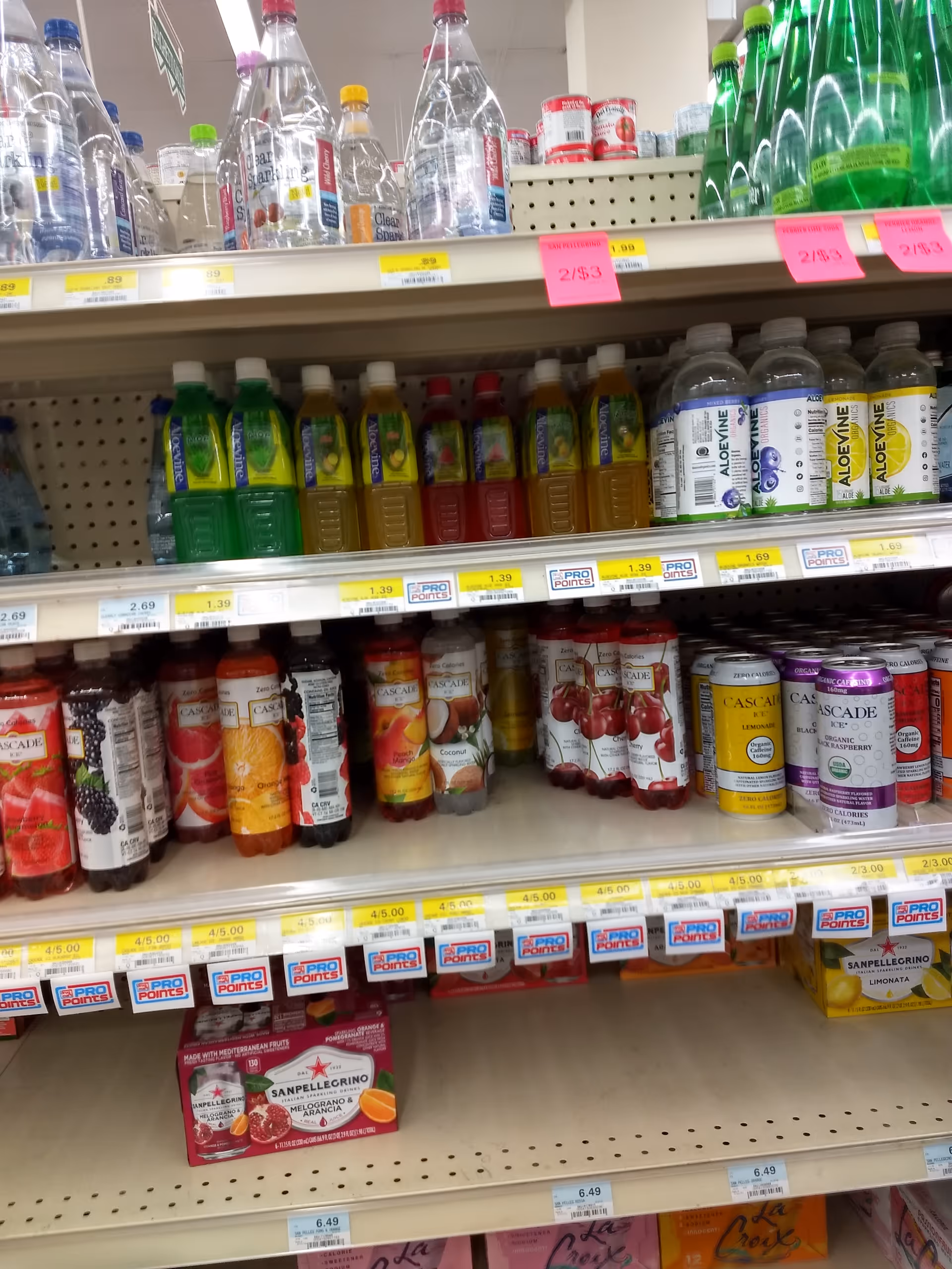 Aisle shelves filled with bottled beverages and juices in a discount drug mart