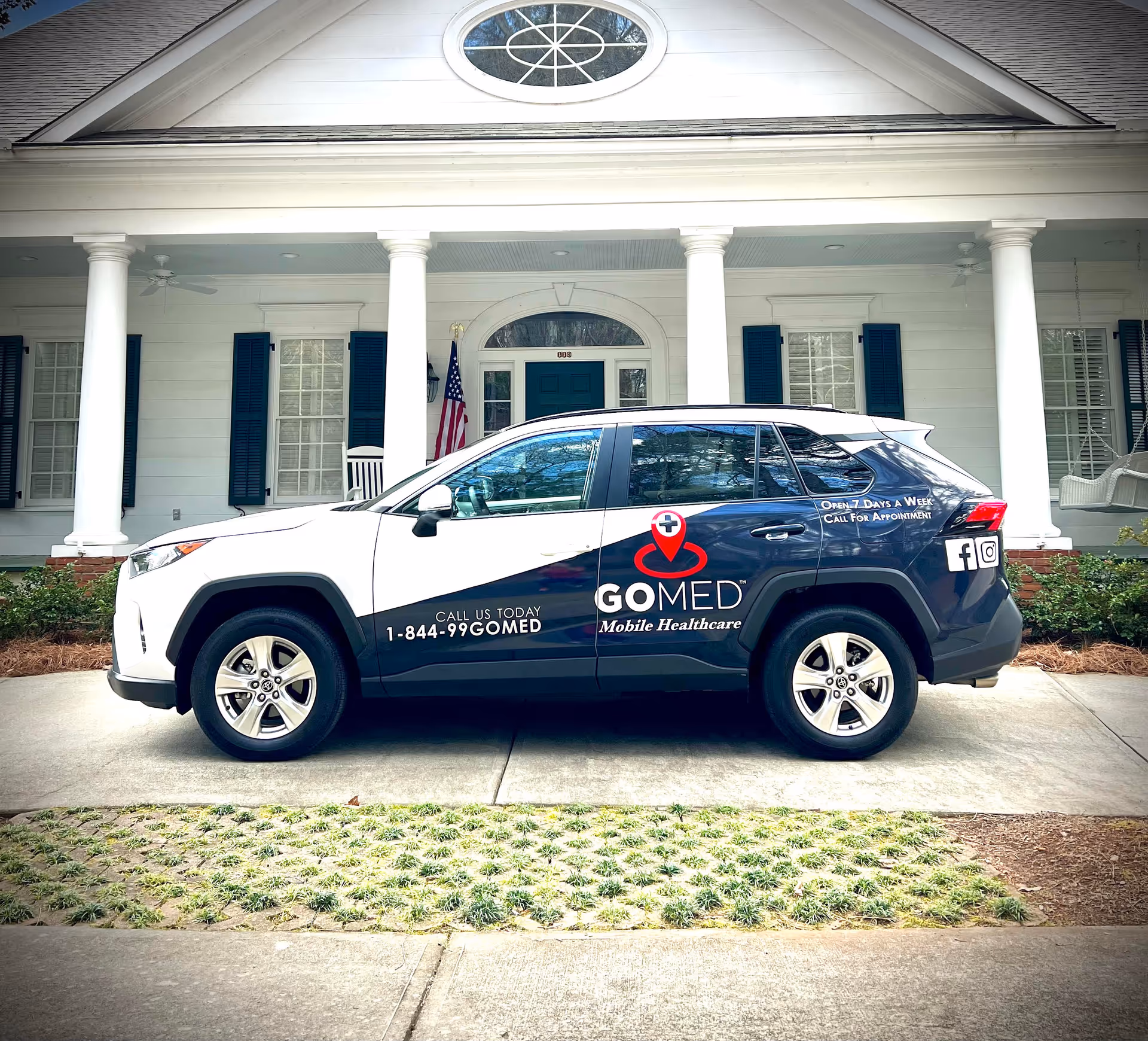 White, columned building front with a GOMED mobile healthcare vehicle parked outside.