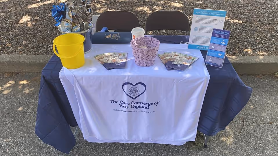 Promotional outdoor table setup for The Care Concierge of New England with brochures.