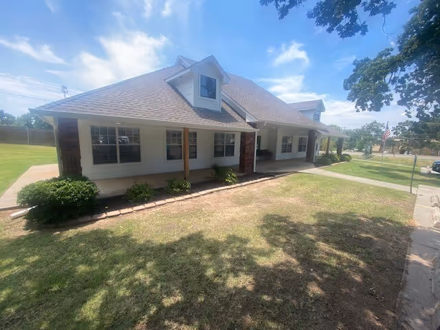 A single-story senior living facility with a front porch and windows.