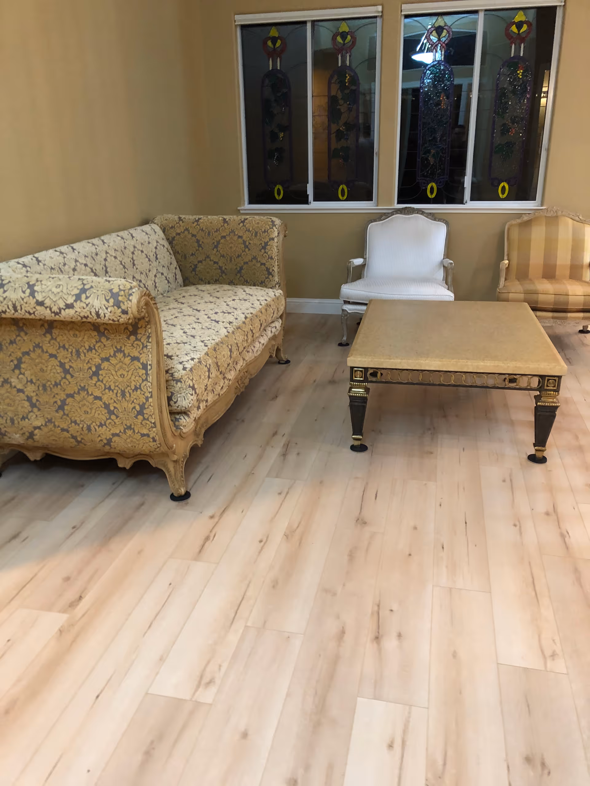 Cozy living room with patterned sofas, chairs, and a central coffee table.