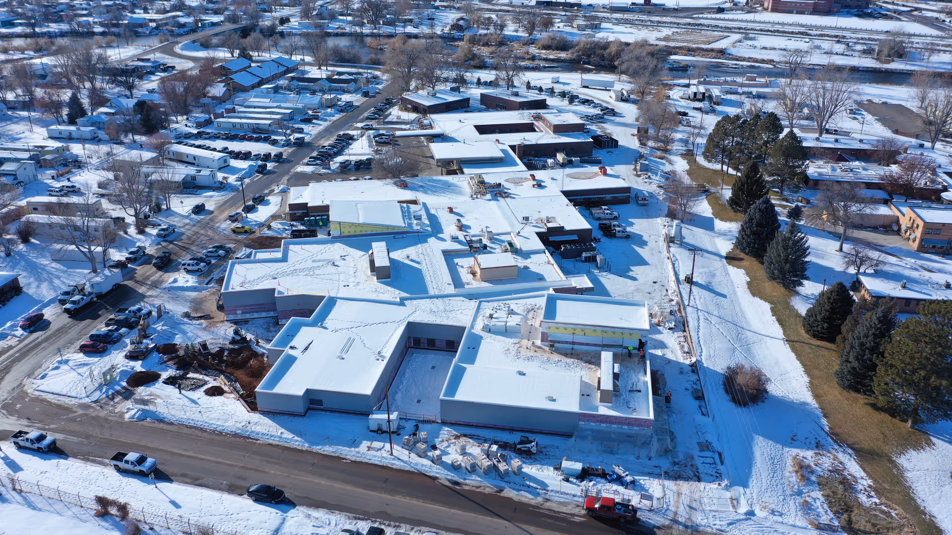An aerial view of a snow-covered senior living campus with connected buildings and parking.
