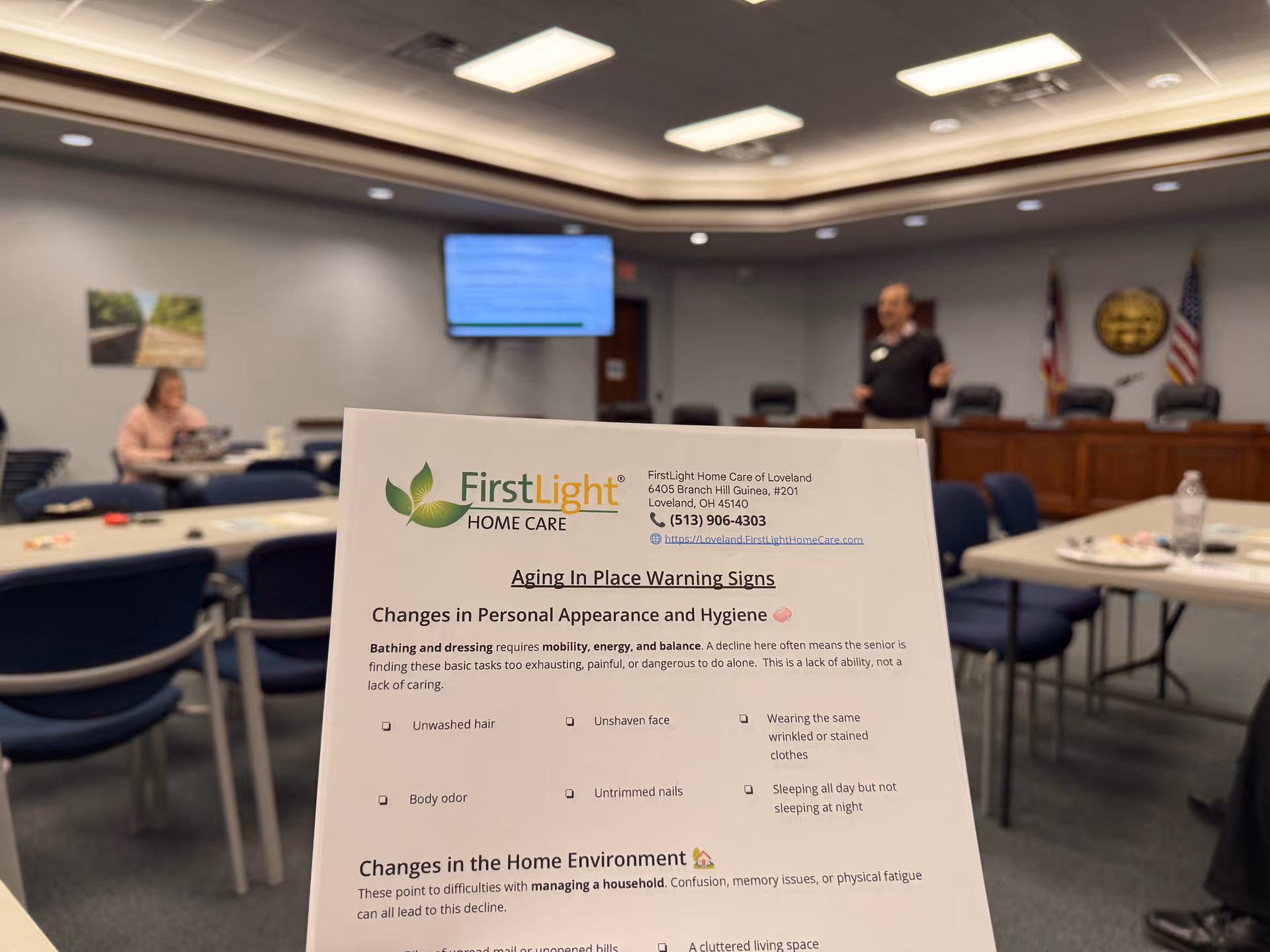 Interior conference room at FirstLight Home Care Loveland with a foreground information flyer.